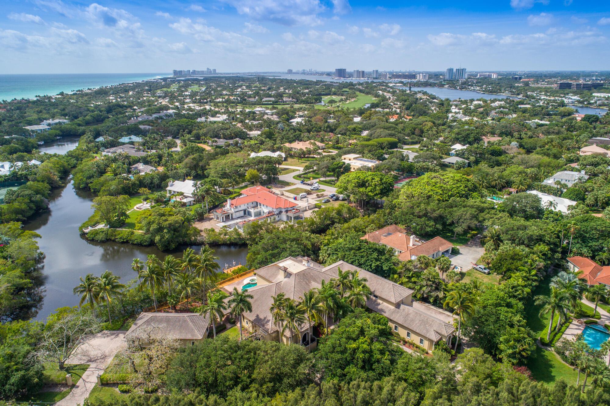 Discover an impressive 18,000 square foot residence, complete with a guesthouse, nestled on a generous 1.5-acre lot boasting coveted southeast exposure mere steps from beach access within the prestigious Seminole Landing community. Behold breathtaking views of the tranquil lagoon, canal, and preserve from this Mizner-inspired Mediterranean masterpiece! While maintaining its original charm, this home offers a spectacular floorplan with high ceilings and generously sized rooms that seamlessly transition to the expansive outdoor living area, featuring a saltwater pool, spa, and a private dock with a boat lift for smaller vessels. Enjoy the luxury of newer impact glass doors and windows, complemented by hardwood and stone flooring throughout. The spacious downstairs master suite boasts his an walk-in closets, a lavish bathroom suite, and captivating views of the pool and water. The kitchen effortlessly flows into the family room and outdoor living space. Although retaining its original kitchen, flooring, bathrooms, and roof, this well-maintained residence presents an opportunity for modern updates. With its exceptional structure, floorplan, and premier location, this home promises a remarkable living experience.