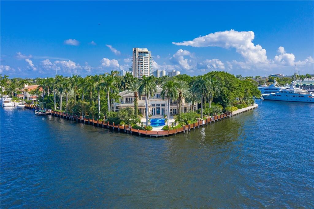 Stunning point lot estate, located in the Harbor Beach community! Situated on over 38,000 sq ft of land and offering a generous 450 feet of deep water frontage, home accommodates a mega yacht w/ additional dockage & unparalleled views. Home includes a Chef's kitchen, Butler's pantry, formal living & dining rooms, library, gym, media room & 2 laundry rooms. Enjoy City & Intracoastal views while sitting comfortably in the numerous entertainment spaces this home has to offer. Fully equipped Smart Home, everything within house can be controlled remotely from your fingertips! Impact glass throughout & whole house generator. Step out into the tropical, resort-like outdoor area complete with lush landscaping and one of the nicest pools in the City!