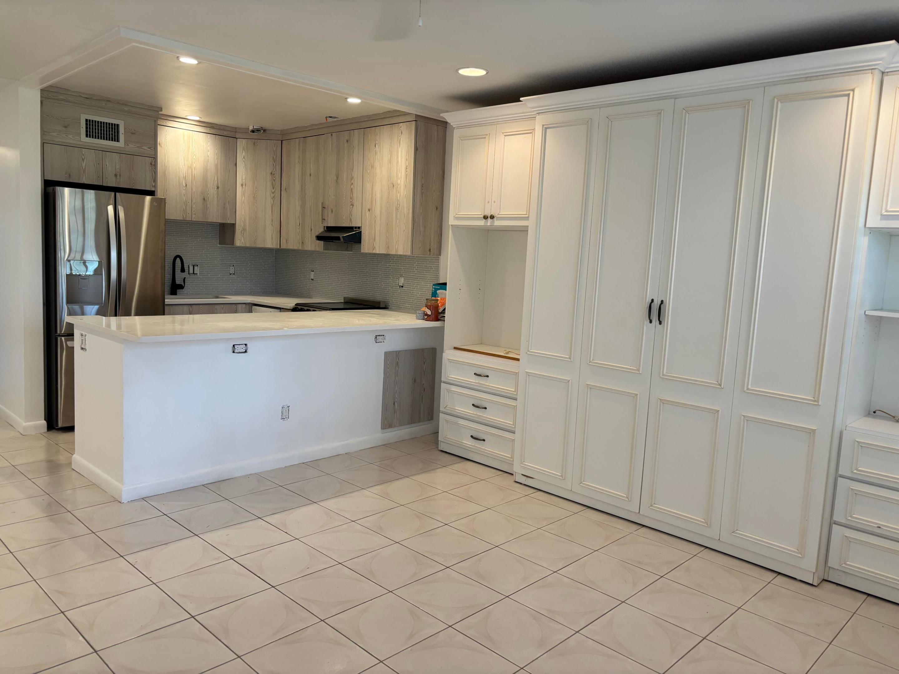We are proud to bring this clean, safe and convenient first floor condo to market in this 55 + community. Open and airy with a helpful Association. The codo has had major upgrades with all required permits. It features cool, fully tiled floors, remodeled bathrooms recently installed, central air, cusom  kitchen cabinetry, white quartz countertops, SS appliances, electric panel, queen size Murphy bed, Bahamas shutters, ceiling fans, recessed lighting, basic cable and condo fees included in rent, rear screendoor/parking access, convenient parking spot in front of door.No need to carry groceries or packages long distances. Come and enjoy this fabulous condo with its many community amenities, such as 12 swimming pools, tennis courts, boating, clubhouse and courtesy buses. Paradise!