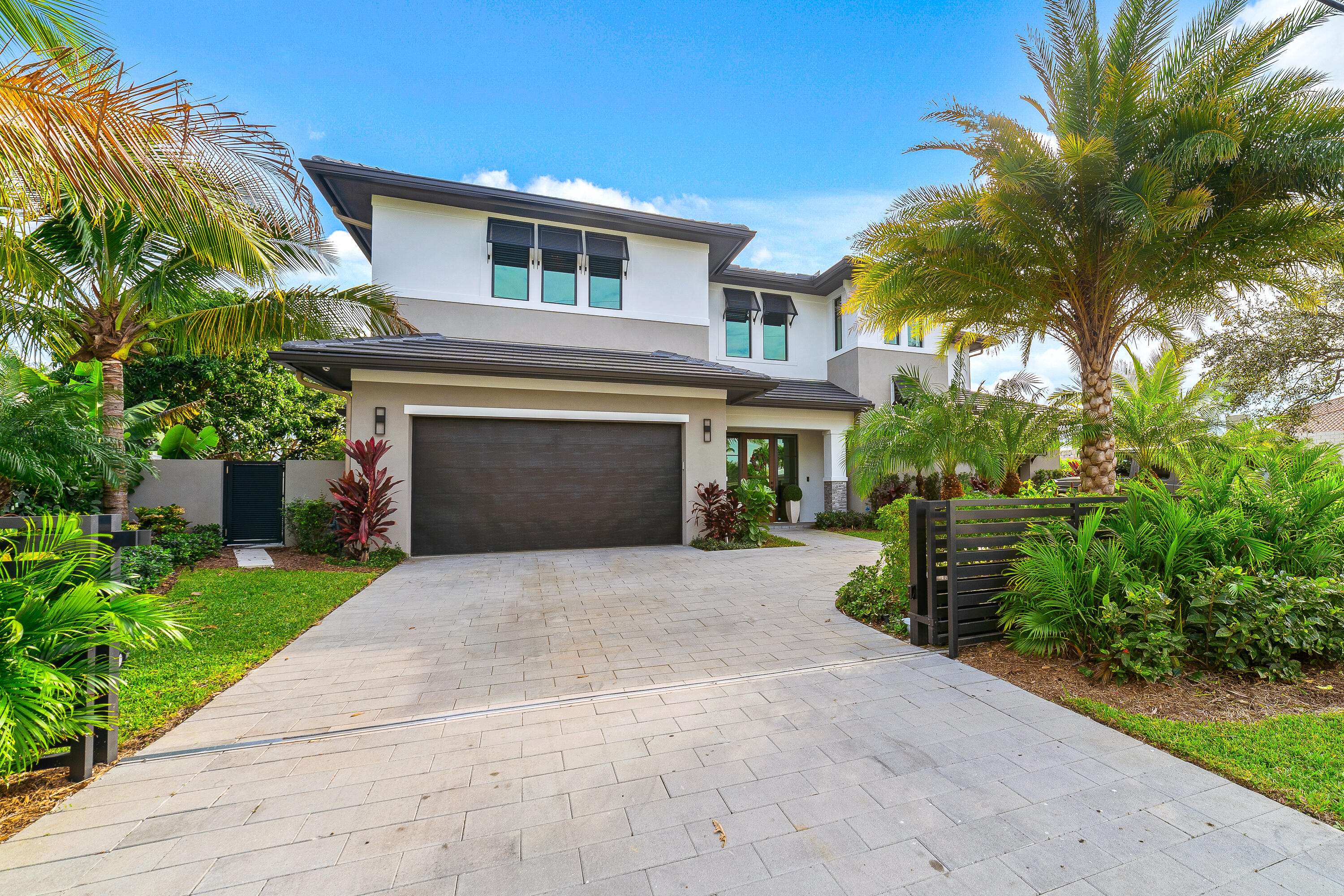 This spectacular New & Modern Home (2021 c/o) located in Bel-Marra, a highly sought-after waterfront community, offers stunning design finishes throughout and a true waterfront PARADISE! Entering the home, you are sure to be captivated by breathtaking water views. Featuring 5 bedrooms and 5 baths, you will revel in an impressively large and open kitchen with spacious dining and living room spaces. You'll enjoy a large bonus room that can double as a bedroom, media room, or game room with an incredible wet bar and ample storage. Also, enjoy a full bedroom/bathroom great for guests on the main level and an additional pool half bathroom. Outside you'll love the ultimate patio with a large salt-water pool & spa. It continues as you walk to your 80-foot dock which has an additional twin jet-ski dock. On the second floor, escape to your unbelievable Primary Suite with floor-to-ceiling windows, walk-in closets with custom built-ins, and a fabulous spa-inspired bathroom featuring dual water closets, dual showers, and a large freestanding soaking tub. Two additional bedrooms with ensuites, an additional family/flex room with a balcony complete the fabulous second floor. Two laundry rooms ensure ease of living (1st & 2nd floor) and Control4 whole-home audio & video security technology. You're sure to be impressed by the exquisite materials and recent upgrades: high impact rated windows and doors, elevator, whole home generator, outdoor kitchen, professional lushly landscaping w/up lighting, automatic front security fence, and wireless blinds. Conveniently located close to Boca Inlet, providing open ocean access in no time at all. Wholefoods, Trader Joe's, Mizner Park, and Spanish River Beach are just around the corner, and minutes away from I-95! The home can be purchased, turnkey, with all luxury/designer furnishings as well. With this exquisite home, you get the luxury of brand-new construction but the added bonus of ample upgrades that require no additional waiting of contractors or expenses. It is ready to enjoy the Florida sun and lifestyle, turnkey today!