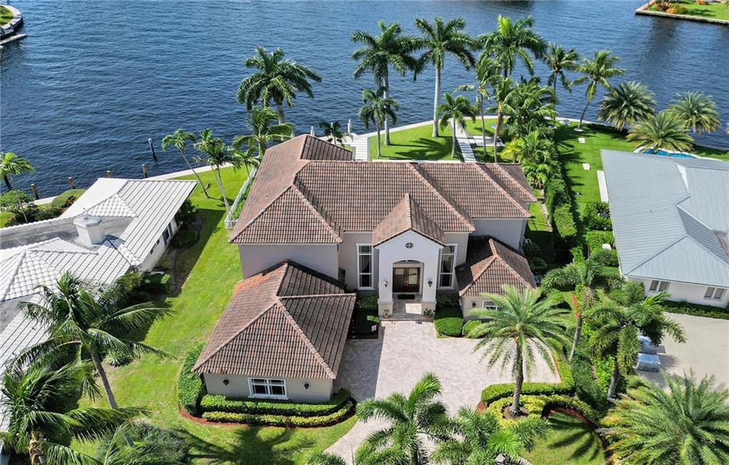 Accepting back-up offers. This exquisite home was custom-built & designed by award winning architect, Mario Cartaya. It boasts 115' of direct Intracoastal views from every occupied room, except the Guest Suite. The house was designed & tailored to an oversized lot in order to maximize backyard living/play areas and to capture the expansive panoramic views. Truly one of a kind! The first floor living spaces have rare Brazilian Rosewood floors-hardest wood floors available. The entry foyer & staircase are of the highest quality Turkish marble. This 5 bedroom,5 bath home plus office/library showcases custom detailed woodwork with built-in desks, cabinets, shelving and lighting. Experience colorful and magnificent sunset displays off your breezy & expansive balcony, covered patio & back yard.