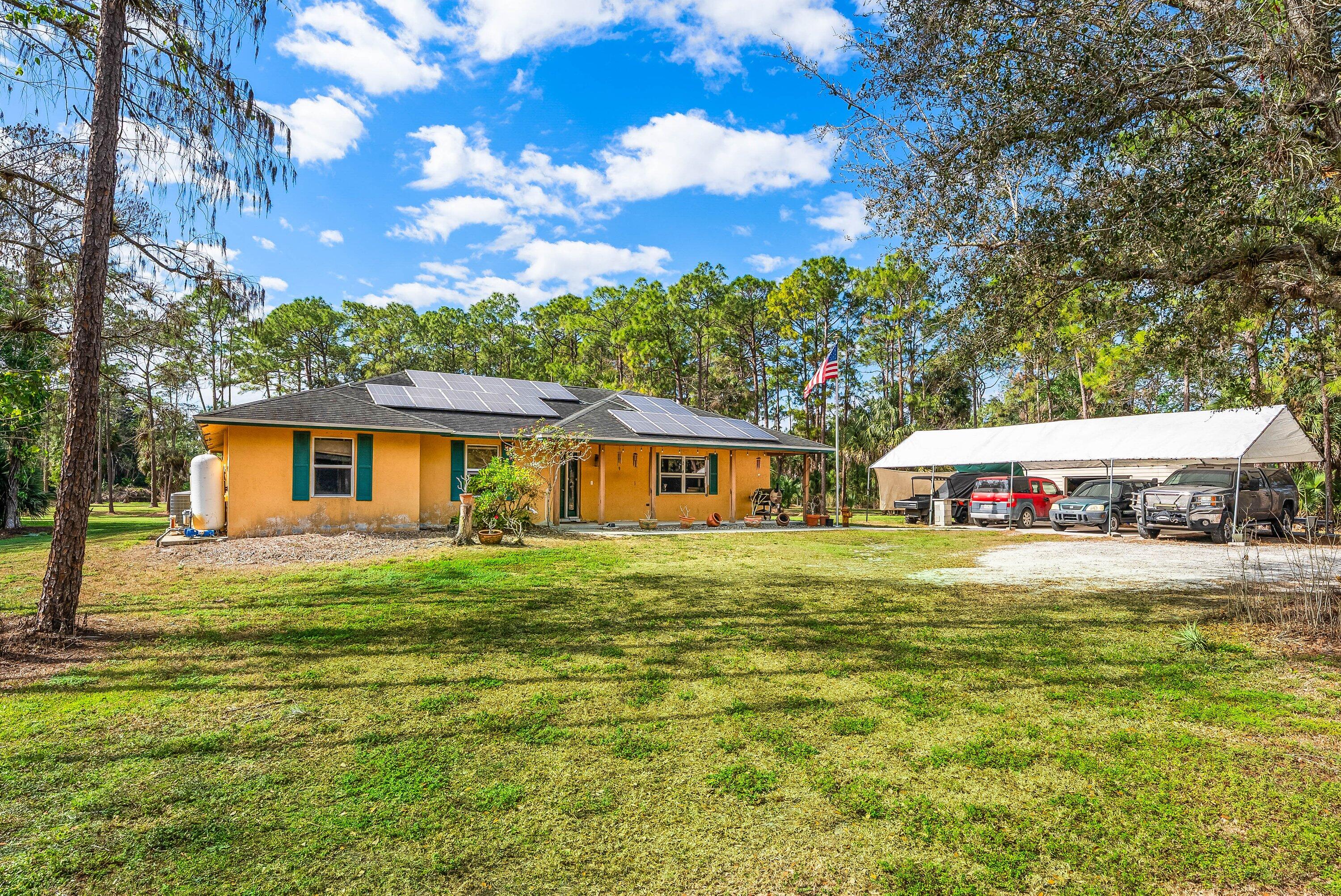 If your in the market for an amazing pool home this stunning Ranch style home on  a fenced 5 ACRE lot is a must see! This amazing 3 bedroom 2 bath pool home features an open concept with vaulted ceilings which give the home a foot print that feels much larger than it is. The living space is centered around the custom designed kitchen, the custom cabinets are topped with beautiful quartz and the kitchen is accented with top of the line appliances. As you make your way to the bedrooms you will notice that they are oversized and feature tile floors and fairly large closets. The primary bedroom is huge with sitting space that leads out to the screened patio. The best part of this home is on the outside. Starting with the large screened patio perfect for outdoor living. The homes saltwater pool has expansive views of the sunning property and is the ideal place to host any event. The home also features a full solar system that supplements FPL, an separate shed/shop with power and a 30 amp camper hookup. This home is a must see if your looking for your own country retreat!