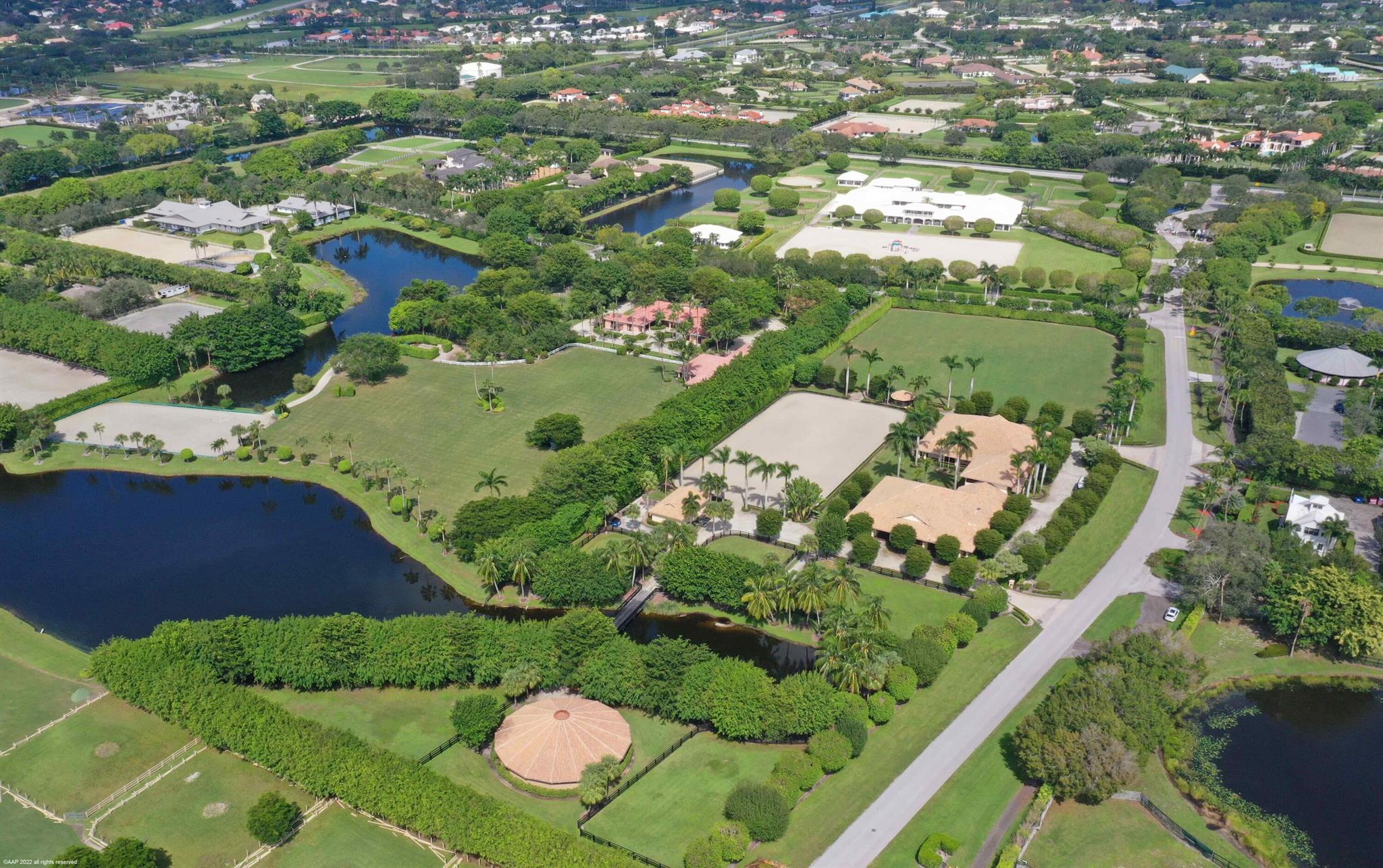 7.78 acres on one of the most premier lots in Grand Prix Village, located only about 1,000 feet from the horse show. 21 stall barn, thoughtfully laid out with two mirrored sides. Each side with a private tack room, laundry, bathroom, storage room and two grooming/wash racks. In addition the barn also includes a separate office and staff kitchen. Upstairs features a one bedroom managers apartment with a large balcony overlooking the courtyard and sand ring. 260 x 260 Bermuda grass Grand Prix field and a 120 x 240 Otto Sport footing sand ring, 6 horse walker and 5 paddocks. Lot's of parking and an additional building for storage. Three separate entrances, one of them to a large driveway for easy trailer parking.
