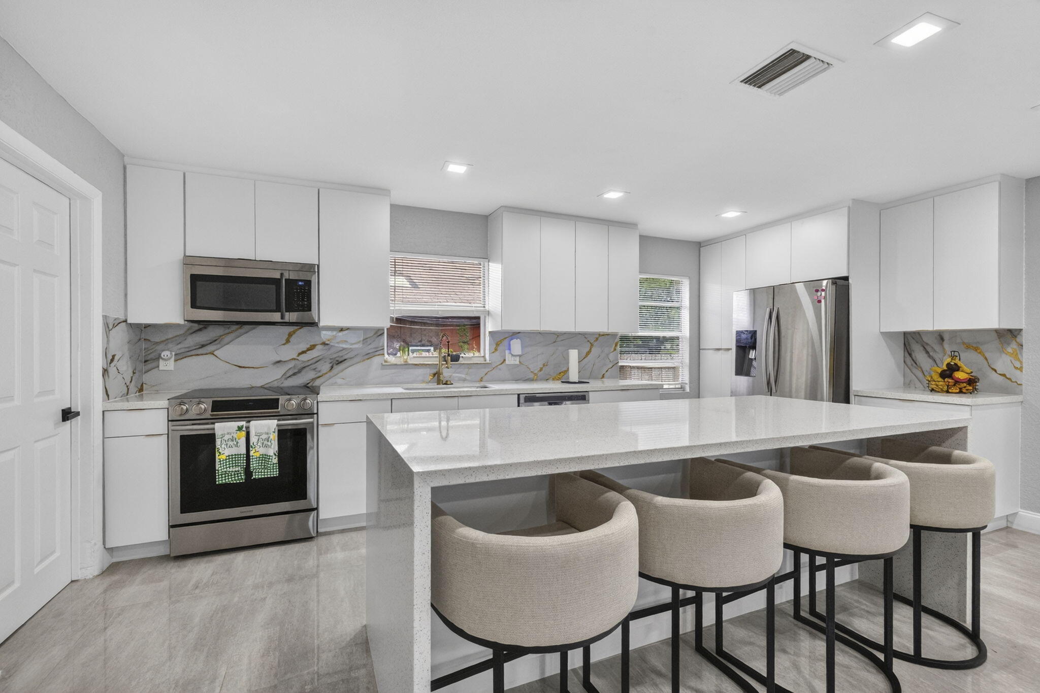 Beautifully remodeled 4-bedroom split-bedroom home situated on a fully fenced corner lot with exceptional curb appeal. This light-filled residence showcases a stunning custom white kitchen featuring sleek quartz countertops, stainless steel appliances, a massive center island, and recessed lighting throughout. The spacious floor plan offers a large laundry room, generous walk-in closets, and comfortable carpeted bedrooms. Elegant porcelain tile flooring enhances the main living areas, while the luxurious custom designed bathrooms feature premium finishes and sophisticated details.    Additional highlights include a brand-new A/C system installed in 2026, just one month old, providing energy efficiency and peace of mind for years to come. Impeccable craftsmanship, modern upgrades, and thoughtful design make this home truly move-in ready. A rare opportunity to own a stylish and spacious home that perfectly blends comfort, functionality, and contemporary living.
