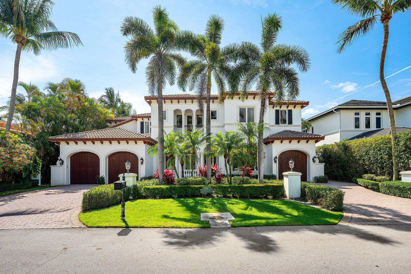 Positioned along the 15th fairway within the prestigious Royal Palm Yacht & Country Club, 1282 Sabal Palm Drive is a private golf course estate defined by timeless architecture, resort-inspired living, and a coveted southeast exposure that fills the residence with natural light from sunrise to sunset. Crafted in 2003 by Bloomfield Construction, the home spans approximately 6,068 square feet of thoughtfully designed interiors, blending elegant entertaining spaces with relaxed everyday comfort. Beyond the stately arrival, the residence unfolds with grand yet inviting proportions. Formal living and dining spaces are complemented by a butler's pantry and a beautifully designed gourmet kitchen featuring premium appliances, a center island, and seamless flow into the home's main gathering areas. The outdoor setting evokes the atmosphere of an exclusive private resort. Surrounded by lush tropical landscaping, the backyard centers around a spectacular beach-entry lagoon-style pool overlooking the manicured fairways beyond. A covered loggia invites year-round outdoor living with a built-in grill, al fresco dining areas, and multiple spaces for entertaining or quiet relaxation beneath the South Florida sky. Privately positioned, the grand primary suite serves as a luxurious retreat, complete with a spacious sitting room, a spa-inspired bath, and a private balcony offering tranquil golf course views. Five bedrooms, five full baths, and a three-and-a-half-car garage provide exceptional comfort and flexibility. Modern conveniences are seamlessly integrated throughout, including Savant home automation with iPad controls, natural gas, impact windows and doors, tankless water heaters, and a generator, delivering effortless living and peace of mind in one of Boca Raton's most prestigious enclaves.