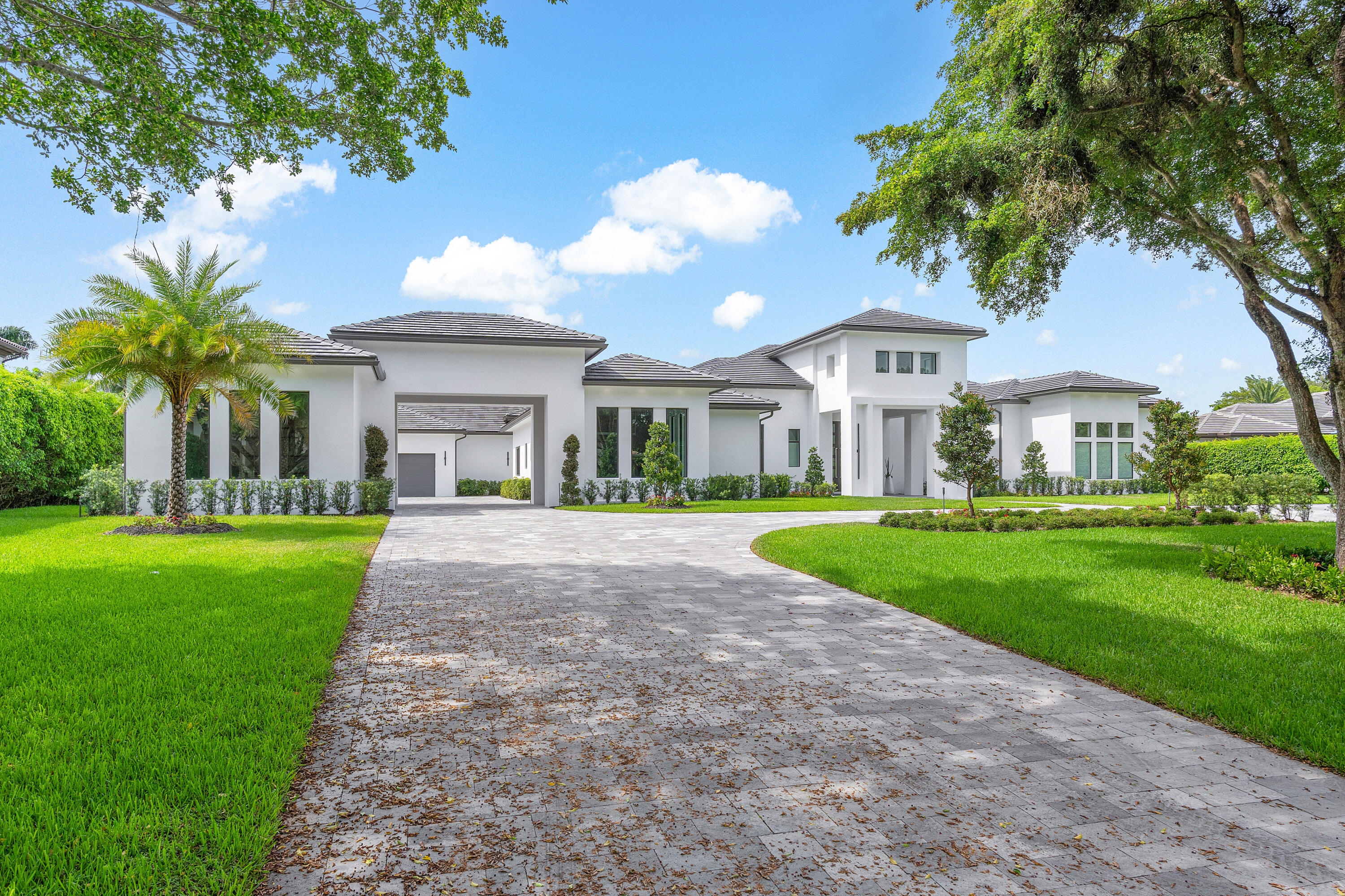This contemporary, newly completed home offers luxurious living on 200 feet of waterfrontage, in guard gated Long Lake Estates. A grand circular paver driveway welcomes you, leading to the homes hidden 6-car garage. Six bedroom suites, each with private bathrooms, light-filled windows, and  walk-in closets. The primary suite is expansive, with lake views, a grand bathroom with steam shower, and enormous closets.   This custom plan featured a three-way split floor plan, with three distinct living spaces. First, a welcoming formal living room with library and grand dining space, then the spectacular kitchen with dinette, and family room. Finally, a voluminous club room, with spaces for billiards, media, bar and more. The grand kitchen sports twin islands, commercial grade appliances and expansive storage. Outside, you'll find a large covered loggia with summer kitchen, 40x18 heated saltwater pool, a paver patio, and large grassed areas for recreation and privacy.