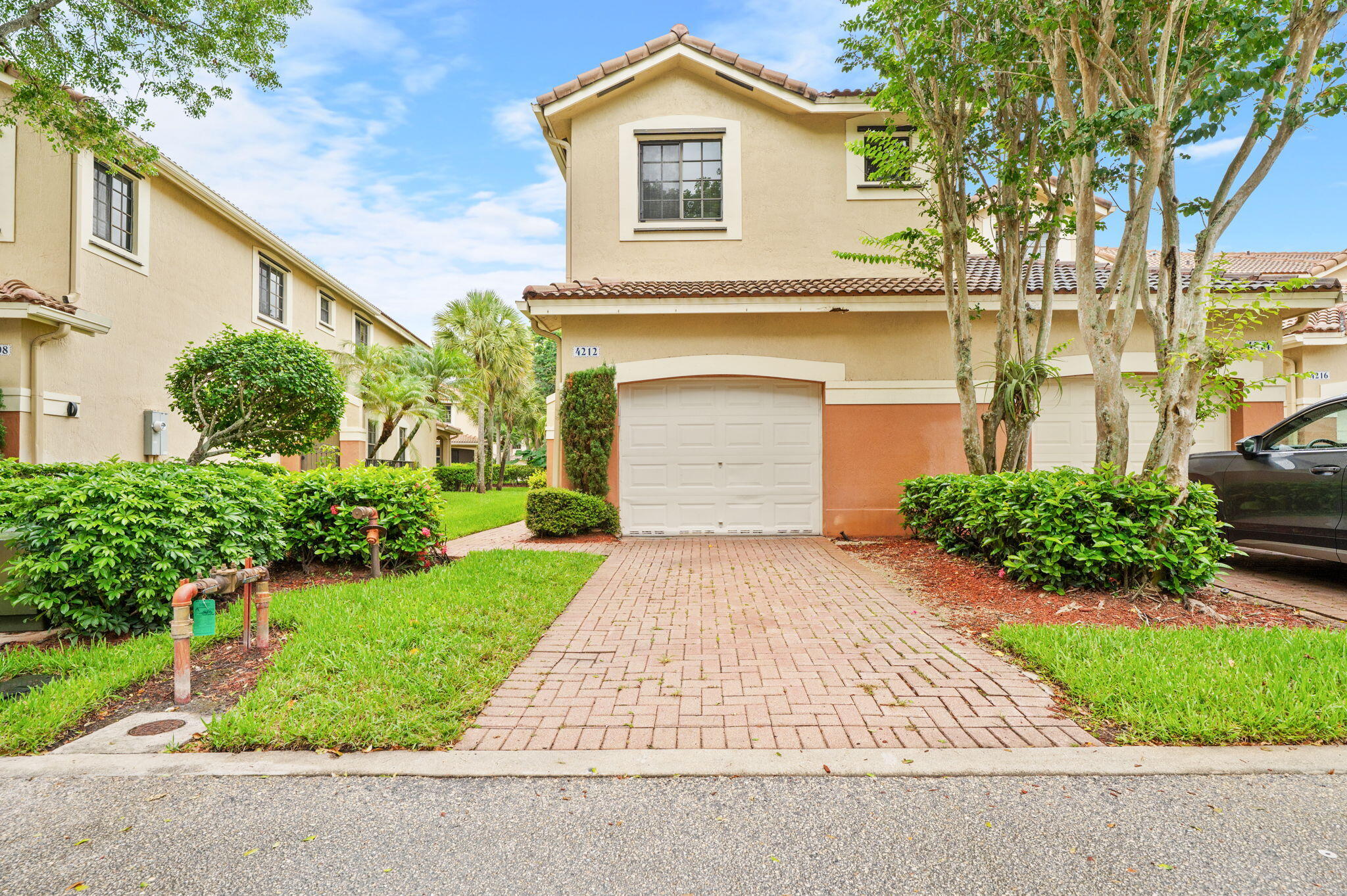 Mediterranean-style corner-unit townhome in a gated Weston community featuring a brick-paver driveway, oversized 1-car garage with extra storage, and a covered, screened patio overlooking peaceful green space. Neutral tile flooring throughout the main level and a contemporary kitchen with new stainless steel appliances. All 4 spacious bedrooms are upstairs. Durable luxury vinyl flooring covers the stairs and entire second floor. The grand primary suite features tray ceilings and an en-suite bath with dual sinks. Washer and Dryer downstairs. Enjoy a community pool and an unbeatable walkable location near top-rated schools, parks, the library, and more.