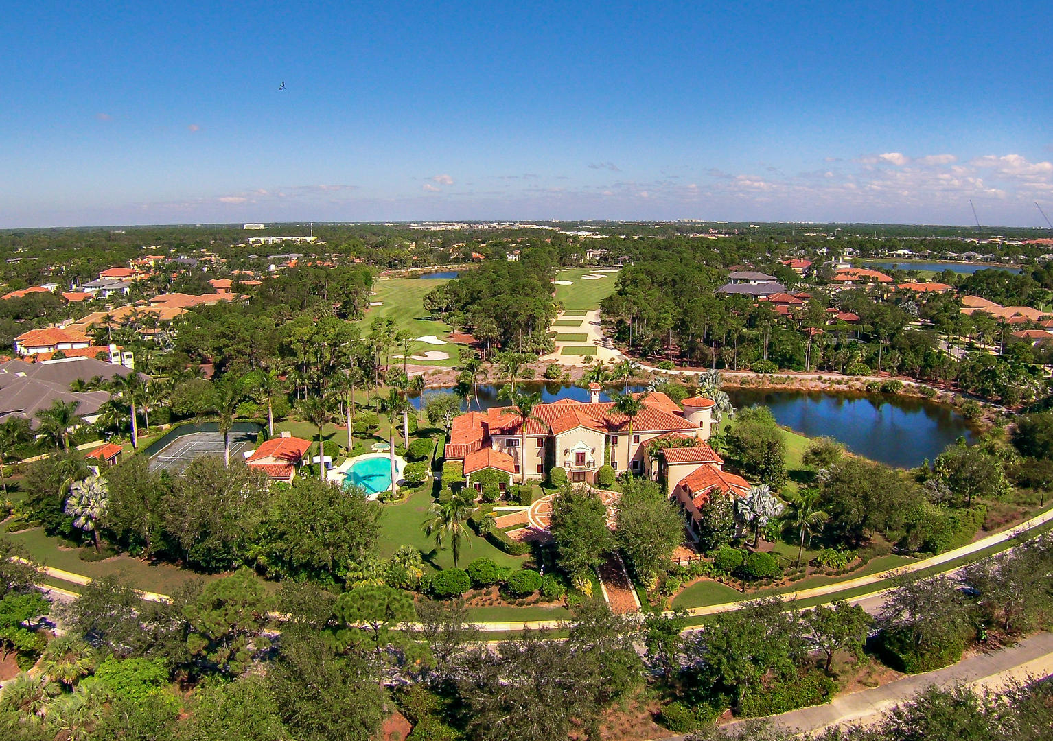 Situated on two acres of private meticulously landscaped grounds, panoramic lake and golf course views surround this custom residence with the feel of a modern-day palazzo. Elegantly crafted with fine finishings, custom moldings, oasis like outdoor accommodations. private tennis court, custom large pool, several covered loggia/entertaining areas, bar and full summer kitchen. This exceptional 6-bedroom 10.1 bath, ±16,860 total sq. ft. located in Old Palm, hailed as one of the most exquisite clubs in the world featuring a 18-hole Raymond Floyd designed Championship Golf Course, state of the art practice studio, full service salon and spa, private dining, wine room, beach club access, and fitness room with private instruction.