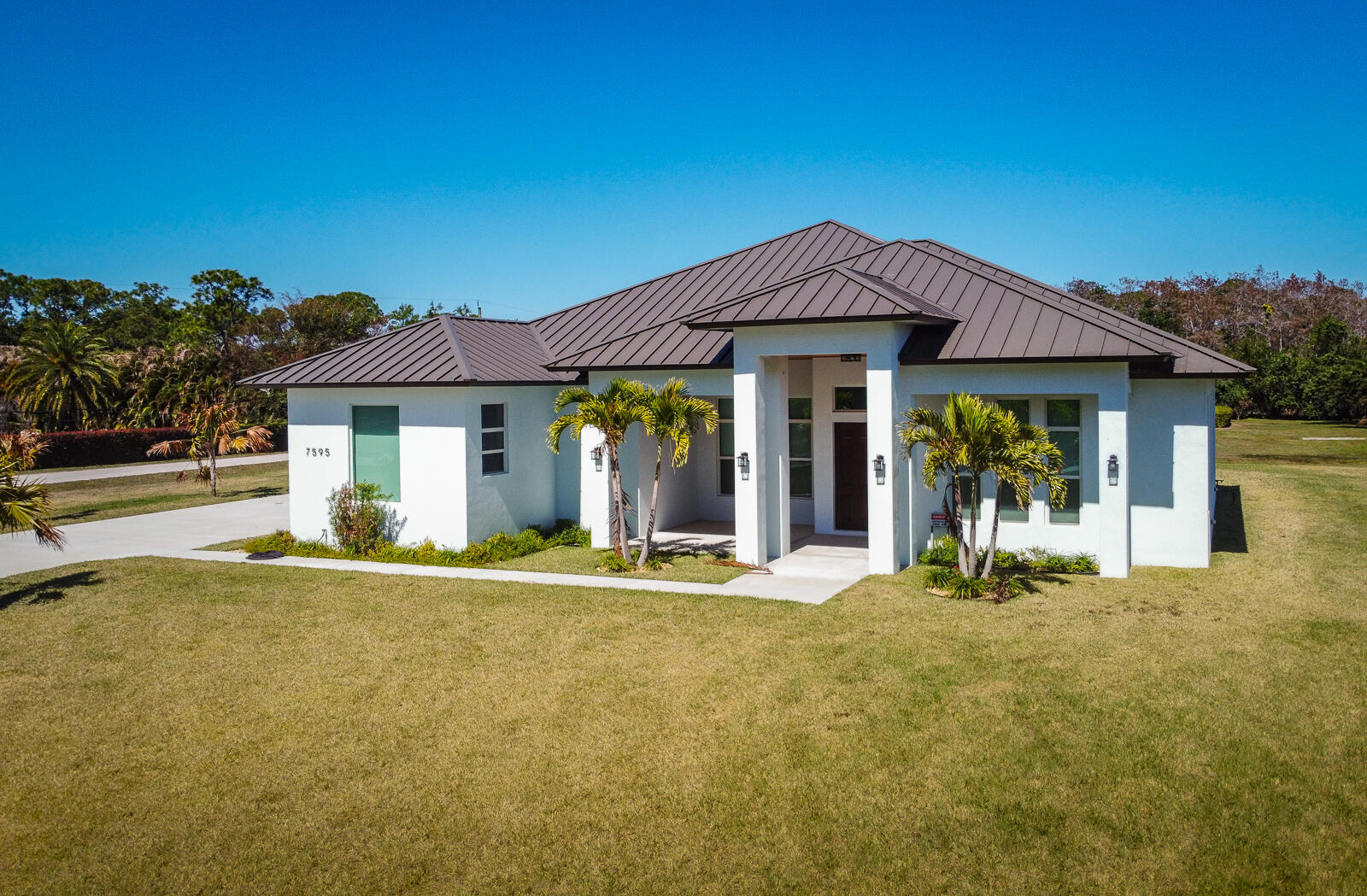 $400,000 REDUCTION.OWNER SAYS SELL. BRAND-NEW luxury CBS home on a 1.16-acre corner lot on a paved road in Palm Beach Country Estates features 5 bedrooms plus a den, 4.5 baths, and an oversized 2-car garage. Metal roof and hurricane impact windows. Luxury finishes and 12-foot ceilings throughout. Split floorplan with enormous great room at the center. An underground propane tank supplies the kitchen range, water heater, and summer kitchen. Open kitchen with high-end stainless-steel appliances and large center island. Master bedroom features two large walk-in closets and a master bath with standalone bathtub, dual vanities, and separate shower. Hobby/extra room off the great room with lots of sunlight. Two A/C zones. Large, covered porch with frameless screen. Opportunities to purchase a brand-new home in this subdivision are rare -very few vacant lots left. Palm Beach Country Estates features quiet country living with no HOA, city water, and close proximity to area amenities such as Alton Town Center and Abacoa.
