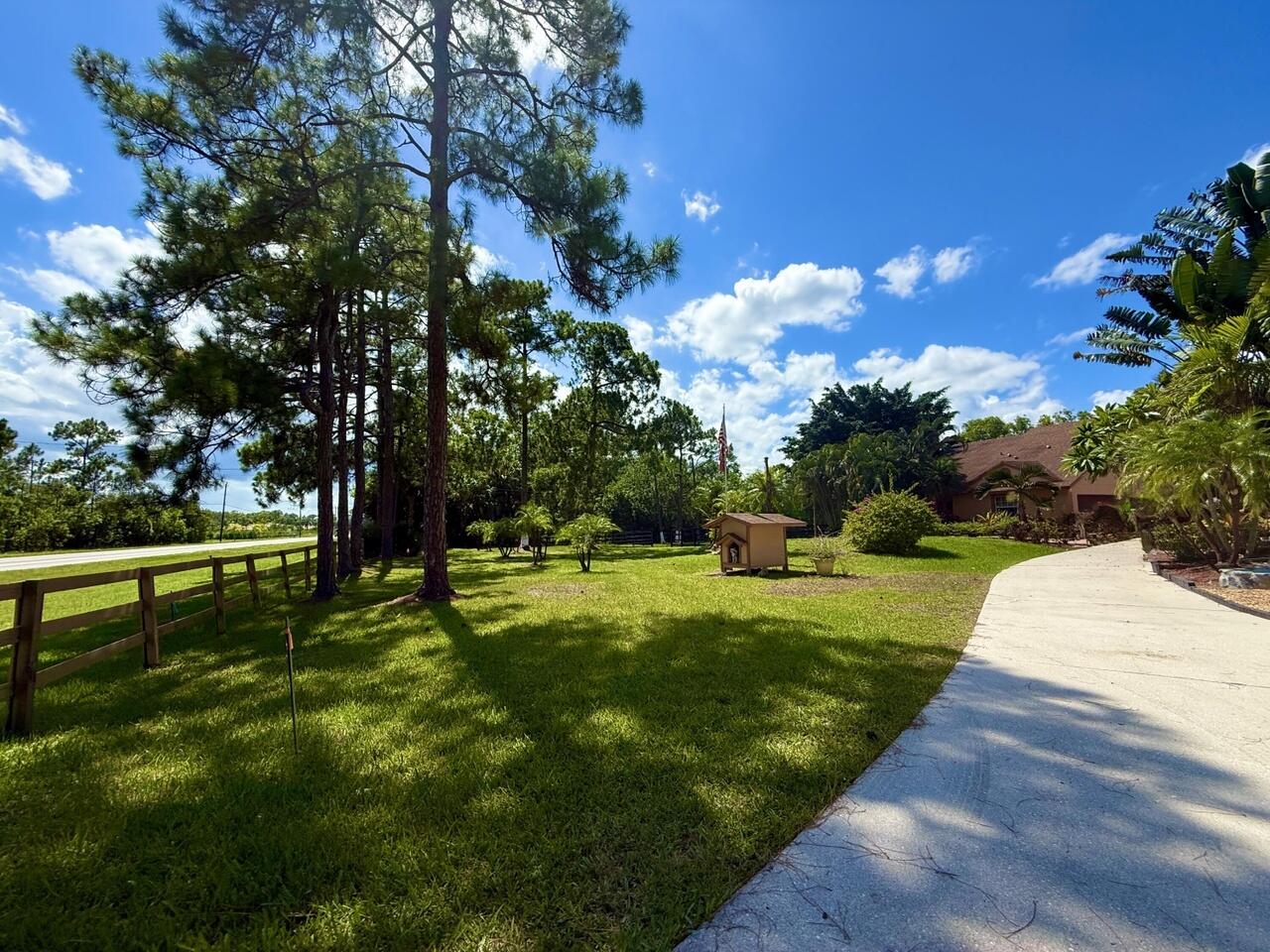 Welcome to this charming three-bedroom, two-and-a-half-bath residence located in The Acreage. This two-story single-family home offers 1,328 square feet of finished living space, providing comfortable quarters for various living arrangements. Situated in the acreage subdivision, this residence presents an excellent opportunity for those seeking a practical home in The Acreage, Florida.  VACANT LAND ON SIDE OF HOME AVAILABLE FOR LEASE FOR $1000 MONTHLY Landlord takes care of the the bi-weekly pool maintenance.