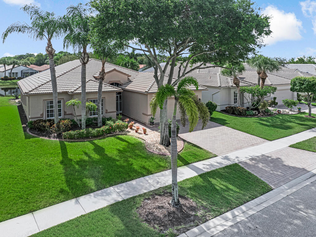 From the moment you step inside, you'll be captivated! This beautifully customized home features a spectacular wide-open floor plan designed for today's lifestyle, creating an expansive great room that seamlessly flows into a stunning, redesigned kitchen. Breathtaking panoramic lake views surround you from nearly every room, filling the home with natural light and creating a serene backdrop for everyday living. The impressive kitchen offers 42-inch wood cabinetry, beautiful granite countertops, abundant workspace, and opens effortlessly to the spacious great room—perfect for entertaining. The oversized café area is wrapped in windows, allowing you to enjoy peaceful water views while dining, and the expansive great room provides the same stunning scenery from every angle. Step outside to  Step outside to an enormous, party-sized screened patio overlooking the lake and lush landscaping—an ideal setting for relaxing, entertaining, or simply enjoying Florida's beautiful weather.  Additional features include a 2018 A/C, 2025 water heater, new garbage disposal, kitchen appliances replaced approximately 10 years ago, generator wiring already in place for added peace of mind, and granite countertops in both the kitchen and bathrooms. This exceptional home combines spacious, customized living with breathtaking water views and thoughtful updates, creating the perfect Florida retreat. This is one you won't want to miss!