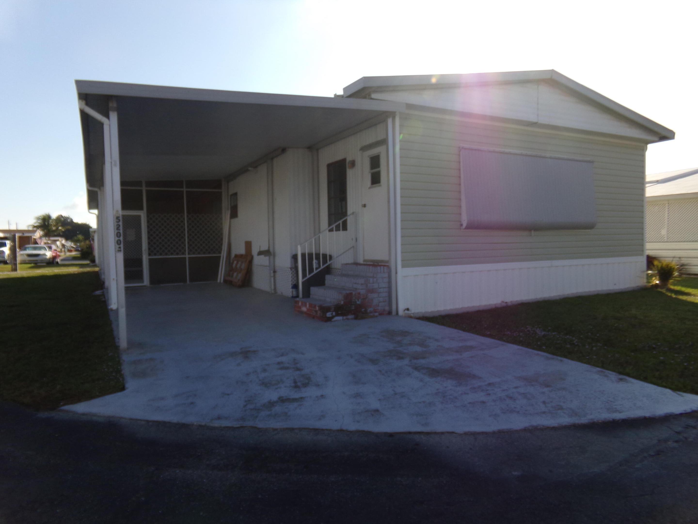 Welcome to this charming 3-bedroom, 2-bathroom manufactured home located in Jamaica Bay Mobile Home Co-Op in Boynton Beach, Florida. This single-story residence offers 1,324 square feet of finished living space, providing comfortable air conditioning from a newer A/C system complimented by 8 ceiling fans placed throughout to keep energy bills low and breezes flowing. You will love the upgraded chef's kitchen, complete with a functional center island, modern soft close drawers and plenty of prep space. The layout offers fantastic flexibility: one of the spacious bedrooms has a private  exterior entrance making it perfect for a guest suite, home office or hobby room. additional peace of mind include a 2018- 40 gallon hot water heater, upgraded electric, and 2025 vapor barrier replacement.  The super- low HOA fee of just $270/month is one of the best in the area and includes internet . water, sewer, and lawn care. This gem is priced to sell!