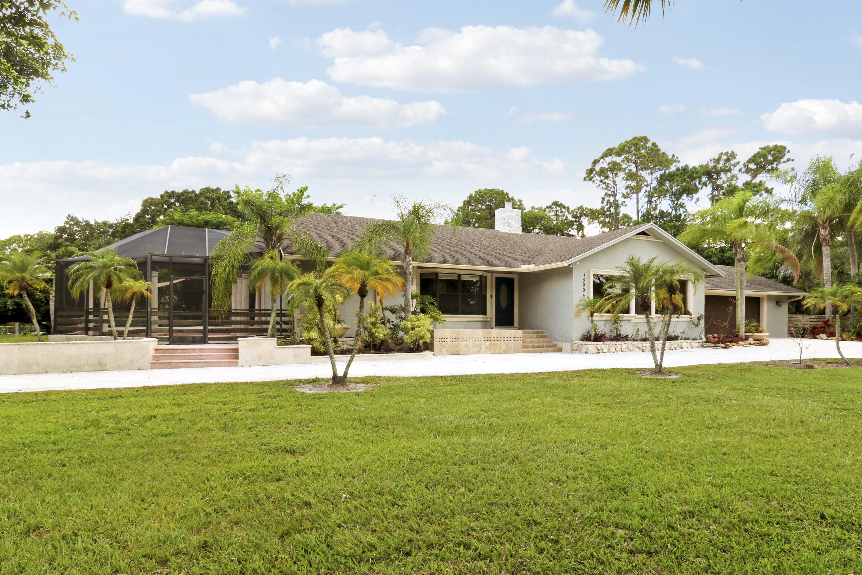 Welcome to your future home in the highly sought-after Palm Beach Country Estates! This beautifully maintained 4-bedroom, 3-bathroom residence offers the perfect blend of comfort, style, and functionality. Step inside to an inviting open-concept floor plan designed for both everyday living and effortless entertaining. Newly remodeled with soaring cedar-vaulted ceilings, and abundant natural light create a warm, welcoming atmosphere throughout. The split-bedroom layout provides added privacy, making it ideal for families or guests. At the heart of the home, the stunning kitchen features a large center island, ample cabinetry, and generous workspace, flowing seamlessly into the spacious family room—the perfect gathering place for relaxing, entertaining, or creating lasting memories.   Step outside and discover your own private tropical oasis. The fully fenced backyard offers exceptional privacy, while the sparkling pool and expansive screened lanai create the ultimate setting for outdoor living. A brand-new pool pump, solar pool heating, and lush landscaping make this backyard a true retreat. The property also offers outstanding versatility with two oversized driveways providing abundant parking, plus a fully powered detached 20' x 20' garage—perfect for an additional vehicle, workshop, hobby space, or storage. RV owners will appreciate the dedicated hookup complete with power and water. Additional highlights include full hurricane protection for added peace of mind, a well-water irrigation system to help maintain the landscape. Combining thoughtful upgrades, exceptional outdoor living, and the privacy of Palm Beach Country Estates, this move-in-ready home is a rare opportunity you won't want to miss.