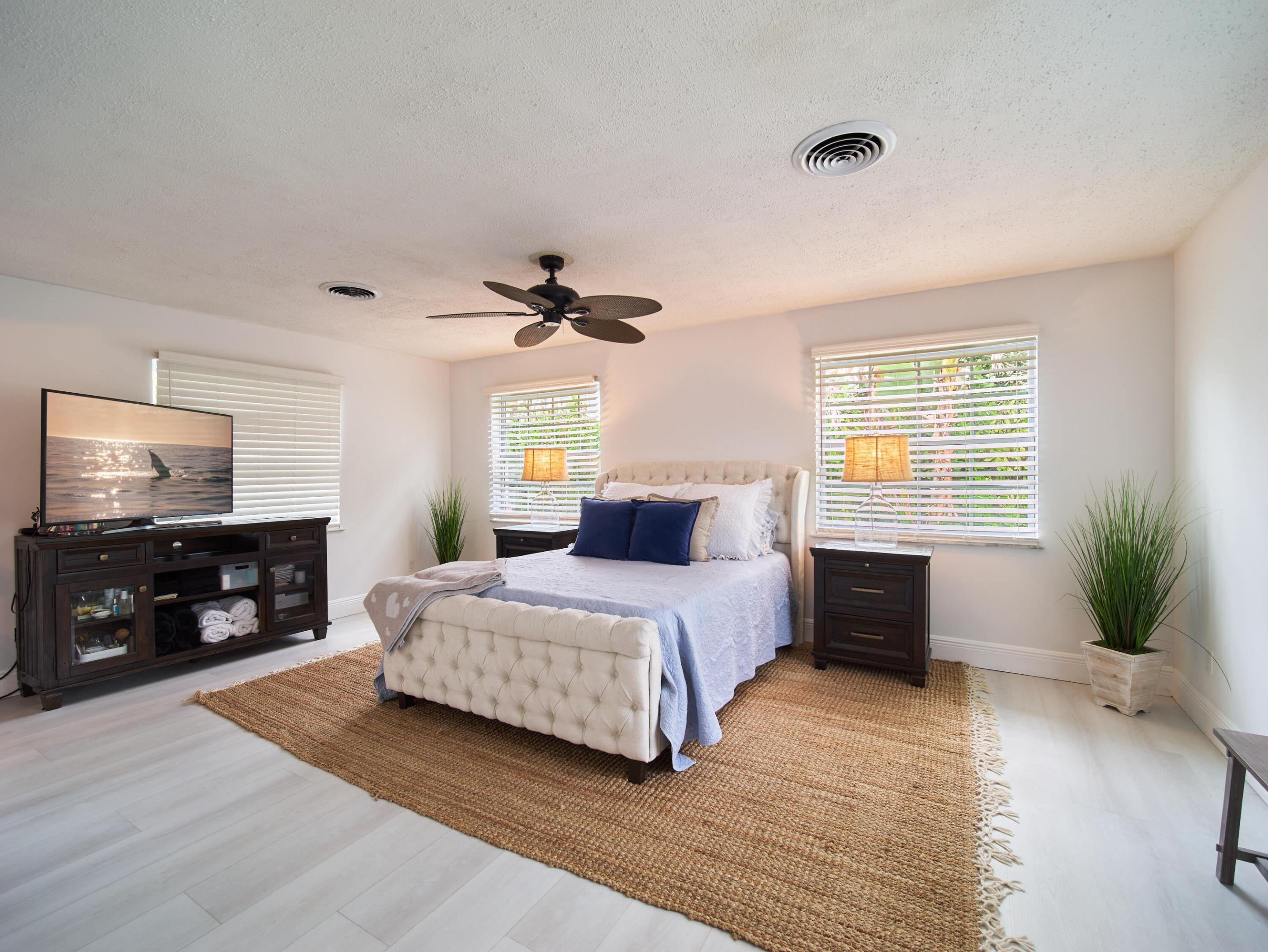 Welcome to your own tropical retreat just minutes from Downtown Jensen Beach! This solid concrete block home is tucked away on a quiet, low-traffic street surrounded by mature coconut palms and lush tropical landscaping. The fully fenced backyard offers a private oasis complete with a composite wood deck - the perfect spot to relax, unwind, or entertain guests. Inside, you'll find a spacious, thoughtfully updated interior with an open-concept kitchen beautifully renovated in 2024, featuring modern finishes and plenty of room for cooking, gathering, and everyday living. Both bathrooms were tastefully updated in 2024 as well. The oversized primary suite is a true retreat, offering an impressive 19' x 15' layout with plenty of space to spread out. Additional highlights include a large laundry room and No HOA, giving you the flexibility and freedom to enjoy your home your way. Located less than a mile from Downtown Jensen Beach, you're just a short walk or bike ride to local restaurants, shopping, live music, festivals, and community events. Plus, the beautiful Treasure Coast beaches are less than 10 minutes away! Don't miss the opportunity to own your own slice of paradise in one of Jensen Beach's most desirable locations.