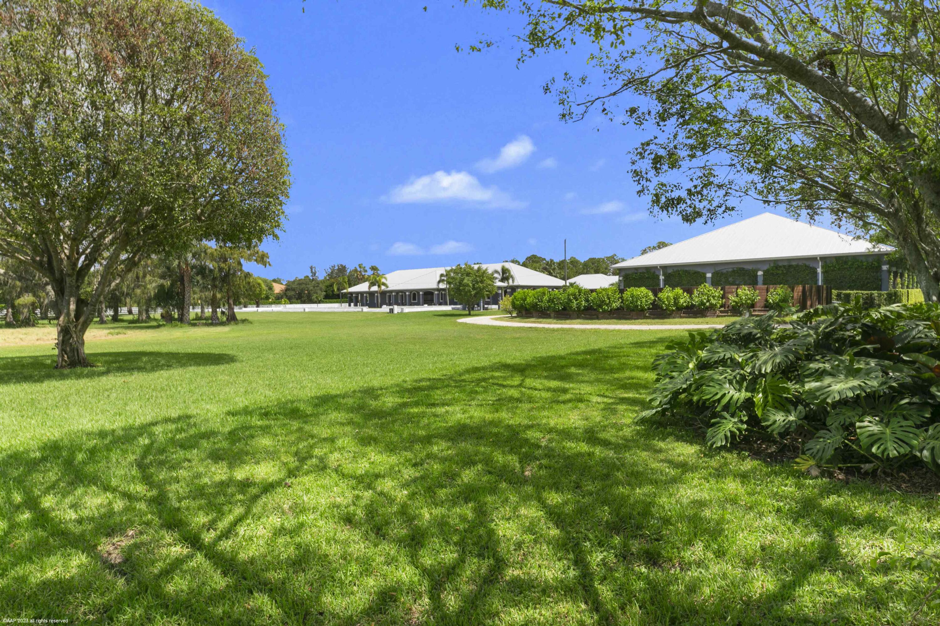This incredible farm in White Fences was built in 2016 with no expenses spared. Sprawling over almost 11 beautifully manicured acres, this farm features two barns, a covered arena, serenity garden, plenty of grooms housing and a large storage building just to name a few. The serene landscaping creates a wonderful environment to train and care for your horses. The outdoor regulation dressage arena, the covered arena and the round pen, all feature RISO systems to create optimal footing regardless of the weather. The center aisle main barn has 16 Rower & Rub Bamboo stalls, all with automatic waterers, commercial fans in each stall and a fly spray system. The well designed, central grooming area has 4 wash/grooming stalls, a veterinary and a farrier area, all with easy access to the tack room The North house, also built in 2016 has 4 bedrooms, 2 bathrooms with convenient access to the main barn for the grooms. The separate storage building houses a salt water treadmill, equipped with a water treatment system and UV lights. In addition, the storage building has 2 mini split AC systems to enable temperature-controlled storage of hay/shavings or any extra equipment. The main barn and North house are hooked up to a generator to ensure no interruptions even during a power outage. The South barn and house were built in 1997 and have a separate entrance to allow for a separate operation. The barn has 8 Loddon stalls, also featuring automatic waterers, commercial fans and fly spray system. Both barns were built with concrete based stalls, all covered by rubber mats to prevent rodent intrusion and ensure the highest comfort for the horses. The South house has 2 bedrooms, 2 bathrooms and a bonus loft area upstairs. The screened in patio overlooks the lush covered arena. Nicely groomed bridle paths lead you from each barn and meets at the covered arena where you can watch the horses train in two raised viewing areas protected by an electric roll down screen for the sunny Florida days, all while listening to your favorite music through the built in sound system. The property has total of 11 paddocks that have been raised with proper drainage underneath to ensure horses can be turned out even during the rainy summer months. The entire property is covered by a camera system for everyone's safety. This property has too many features to mention, schedule a private tour today. 

DISCLAIMER: All information provided to you regarding this Property by Realtor and her associates has been obtained from third parties such as the Multiple Listing Service, public records and other sources. All Buyers should independently verify all information provided regarding this Property. The Sellers, Realtor and Broker make no representation as to the accuracy of this information. All Buyers should perform their own independent due diligence regarding this Property before executing a Contract for Sale and Purchase for this Property.