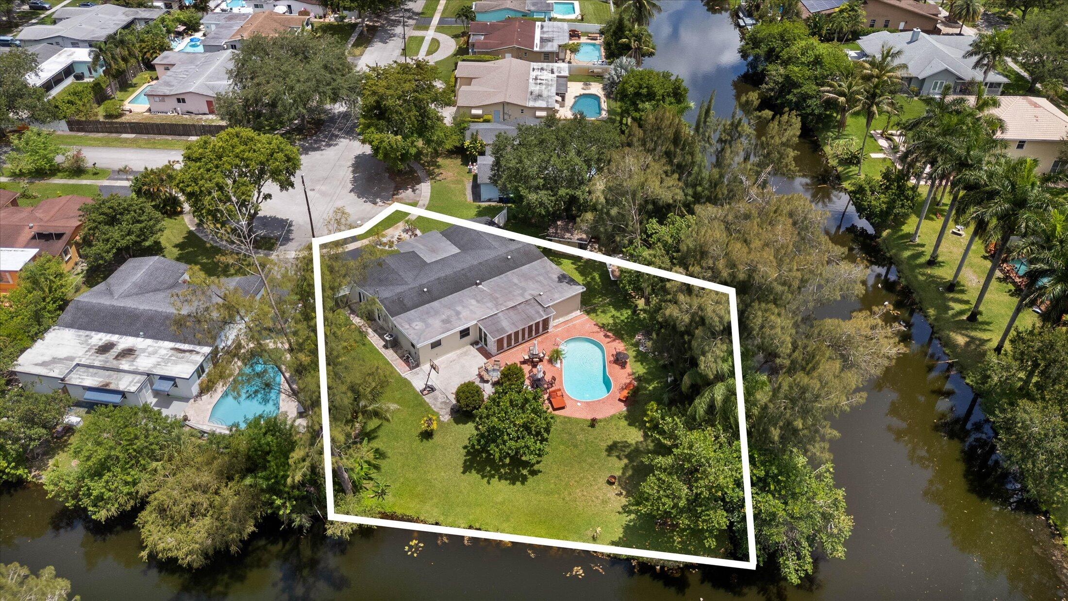 The home you've been waiting for has finally arrived! Situated on an oversized waterfront corner cul-de-sac lot surrounded by towering pine trees, this one-of-a-kind property offers a setting so peaceful you'll forget you're in South Florida—all with no HOA. This 5-bedroom home features a private in-law suite with its own entrance, countertop, sink, and space for a refrigerator and microwave. Recent updates include hurricane impact windows throughout, a newer roof, newer A/C, newer water heater, an updated kitchen, large porcelain tile flooring, and beautifully updated bathrooms. Ideally located in the heart of Cooper City, just minutes from top-rated schools, parks, restaurants, shopping, and the nearby golf course!