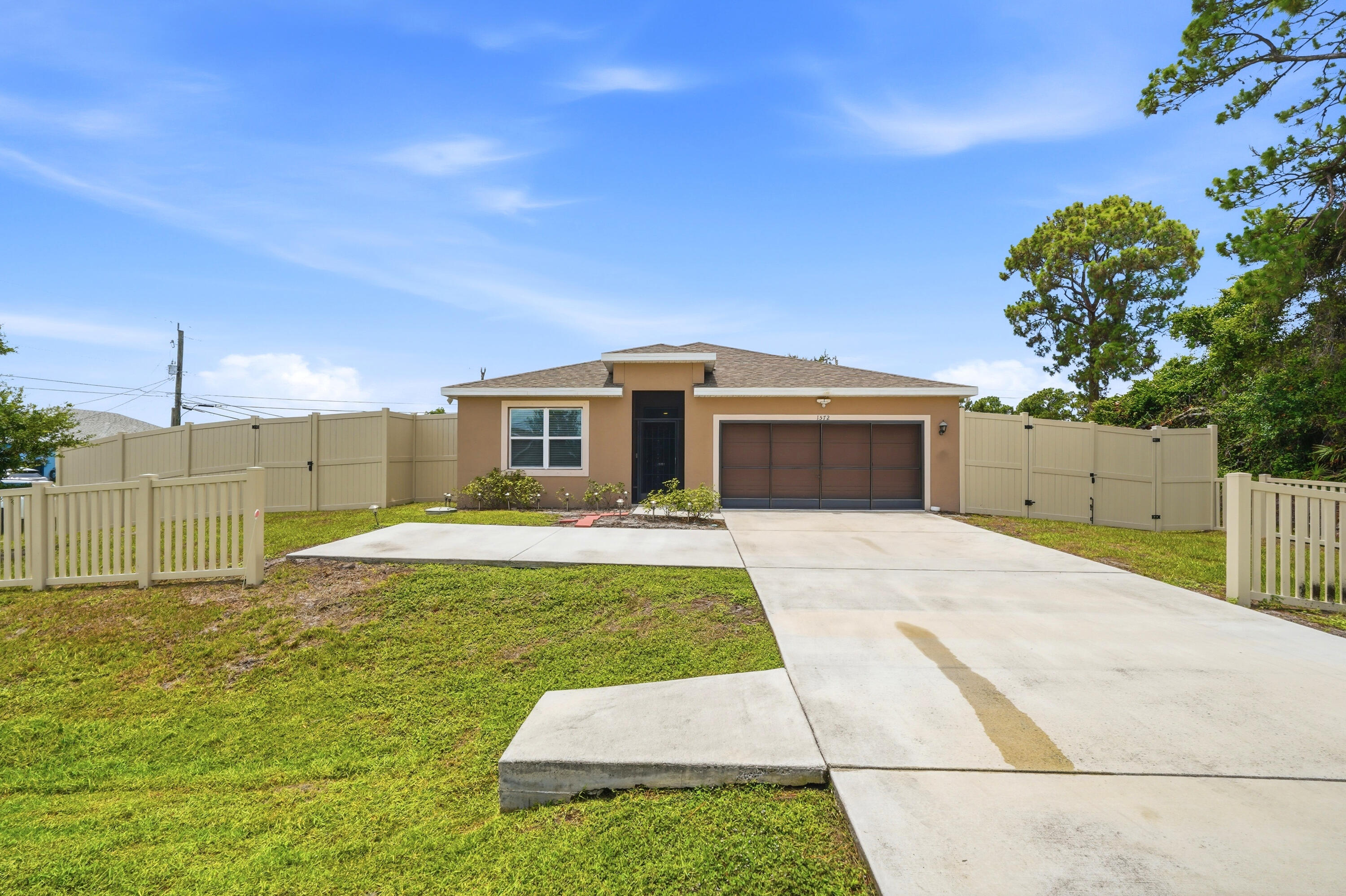 Beautiful CBS construction home built in 2023 offering 4 bedrooms, 2 bathrooms, and 1,916 living sq. ft. on a spacious.27-acre corner lot with NO HOA. This newer home features a bright, open-concept floor plan with tile flooring in the main living areas, stainless steel appliances, a French-door refrigerator, wood cabinets, blinds throughout, and ceiling fans in the living area and all bedrooms. Abundant natural light fills the home, while the kitchen overlooks the living and dining areas, creating the perfect space for entertaining and everyday living. The desirable split-bedroom floor plan provides added privacy, while the spacious primary suite includes dual vanities, a separate shower, and ample closet space.  Enjoy outdoor living with a screened front entry, garage screen, charming white picket fence, and a large privacy-fenced yard featuring three double-gate entrances. The oversized corner lot offers plenty of room for boats, RVs, trailers, campers, and other recreational vehicles. Ideally located near shopping, dining, schools, parks, and just minutes from I-95, providing convenient access throughout the Treasure Coast. Rare opportunity to own a newer CBS home with no HOA, a large corner lot, privacy fence, and space for all your toys in the heart of Port St. Lucie.