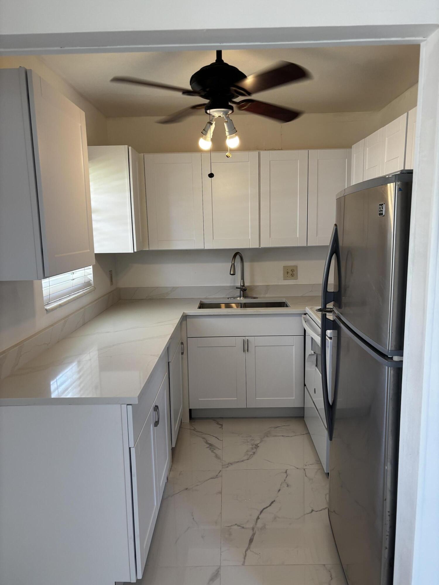 GREAT OPPORTUNITY TO BUY A BEAUTIFULLY RENOVATED 2 BEDROOMS, 1+1.5 BATHROOMS UNIT. GORGEOUS  WHITE MARBLE LOOKING FLOORS AND MAIN BATHROOM WALLS. NEW KITCHEN CABINETS WITH DOUBLE SINK NEVER USED. THIS RARE, FIRST FLOOR, BRIGHT AND   AIRY CORNER UNIT IS A PRIZE IN CENTURY VILLAGE! THE COMMUNITY FEATURES 12 SWIMMING POOLS, TERRIFIC CLUBHOUSE, BOATING, TENNIS COURTS, FITNESS FACILITY AND MUCH MORE. LOCATED 10 MINUTES FROM THE PBI AIRPORT AND GREAT SHOPPING MALLS. A MUST SEE AND BUY !!!! DO  NOT MISS THIS OPPORTUNITY!!!
