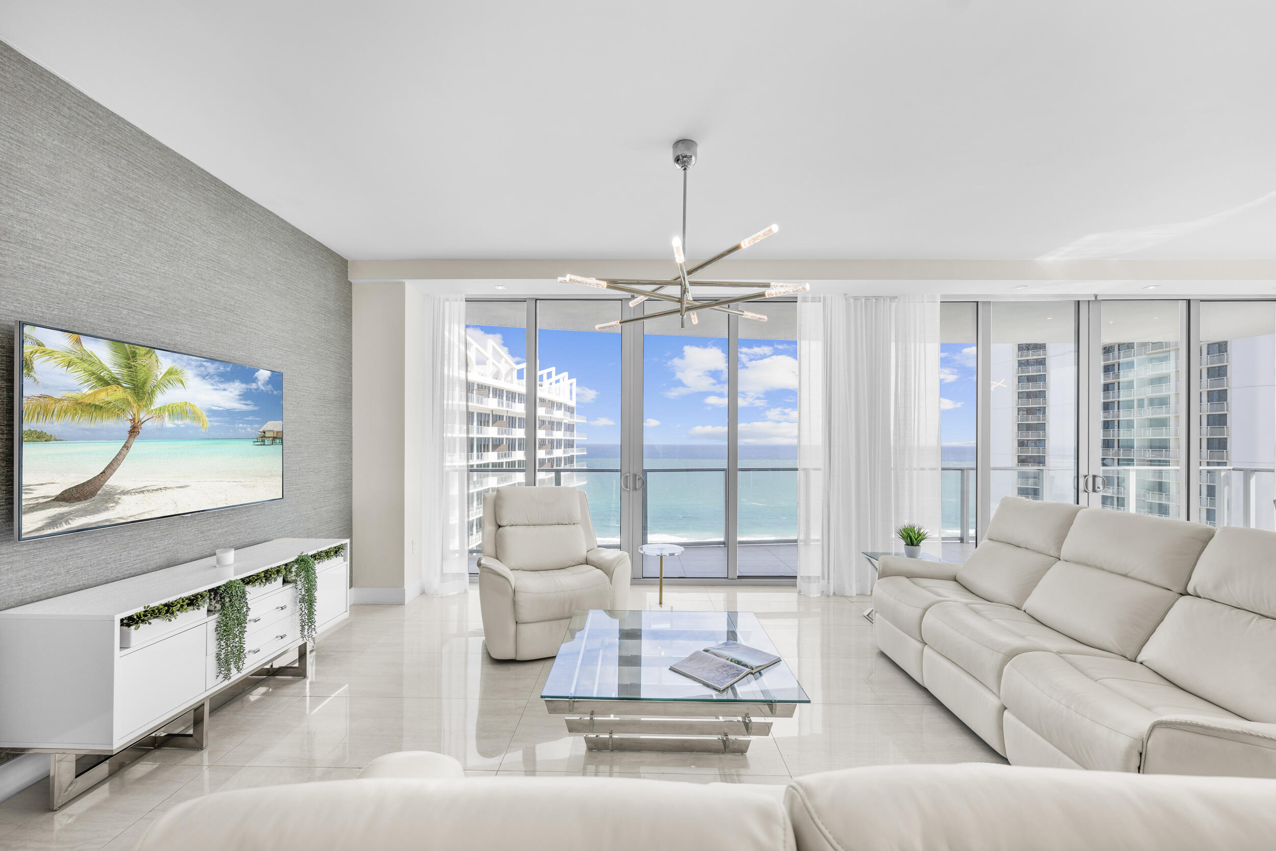 A rare opportunity to acquire a fully furnished and turn key beachfront 2023 built newer construction residence. This residence commands the entire southeastern section of the newly built Peace Tower, offering unparalleled ocean and intracoastal views from the 18th floor. Take in unobstructed water views from every room, sunrise to sunset. At 3,425 total square feet with 2 Bedrooms, 1 Den/Office, 2.1 Baths, wet bar and a laundry room, 1805P is one of the largest offerings available at Amrit Ocean. The expertly designed layout features 2 intracoastal view bedrooms and a spacious den/office which could easily be converted to a 3rd bedroom with the simple addition of a door. Each bedroom has balcony access and floor to ceiling sliding glass doors overlooking the island. Completed October 2023 this residence has been customized, upgraded, furnished and outfitted for the most discerning of buyers. The primary suite features a custom walk in closet as well as a modern spa-like bathroom with a soaker tub, separate shower, dual sink vanity, and a chic frosted glass encased water closet. Both guest bathrooms feature elegant modern designs, and all closest have been custom built with after market upgrades from JL Closets. The open concept living spaces include a gourmet kitchen, formal dining space, living room and a wet bar, all overlooking unobstructed ocean views. The tastefully appointed kitchen comes equipped with Miele appliances, custom cabinetry, quartz countertops,  and an oversized eat-in island with bar seating. The additional wet bar with wine cooler and custom cabinetry further enhance the gourmet offerings of this residence. Additional features include automated blinds throughout, dual zone ADT home security system, and a Savant 'Smart' Home System. 

Enjoy full service dining options on site, spa and wellness offerings, a 24 hour valet, and private beach service. Amrit is one of the ONLY beachfront condominiums that allow immediate nightly rentals, annual leases, seasonal leases and short term rental stays making it a rare opportunity for investors, or owners who would like to utilize the property as an investment while they are away. Situated on 300 feet of pristine beach frontage, Amrit combines the best of luxury waterfront living with modern new construction.
