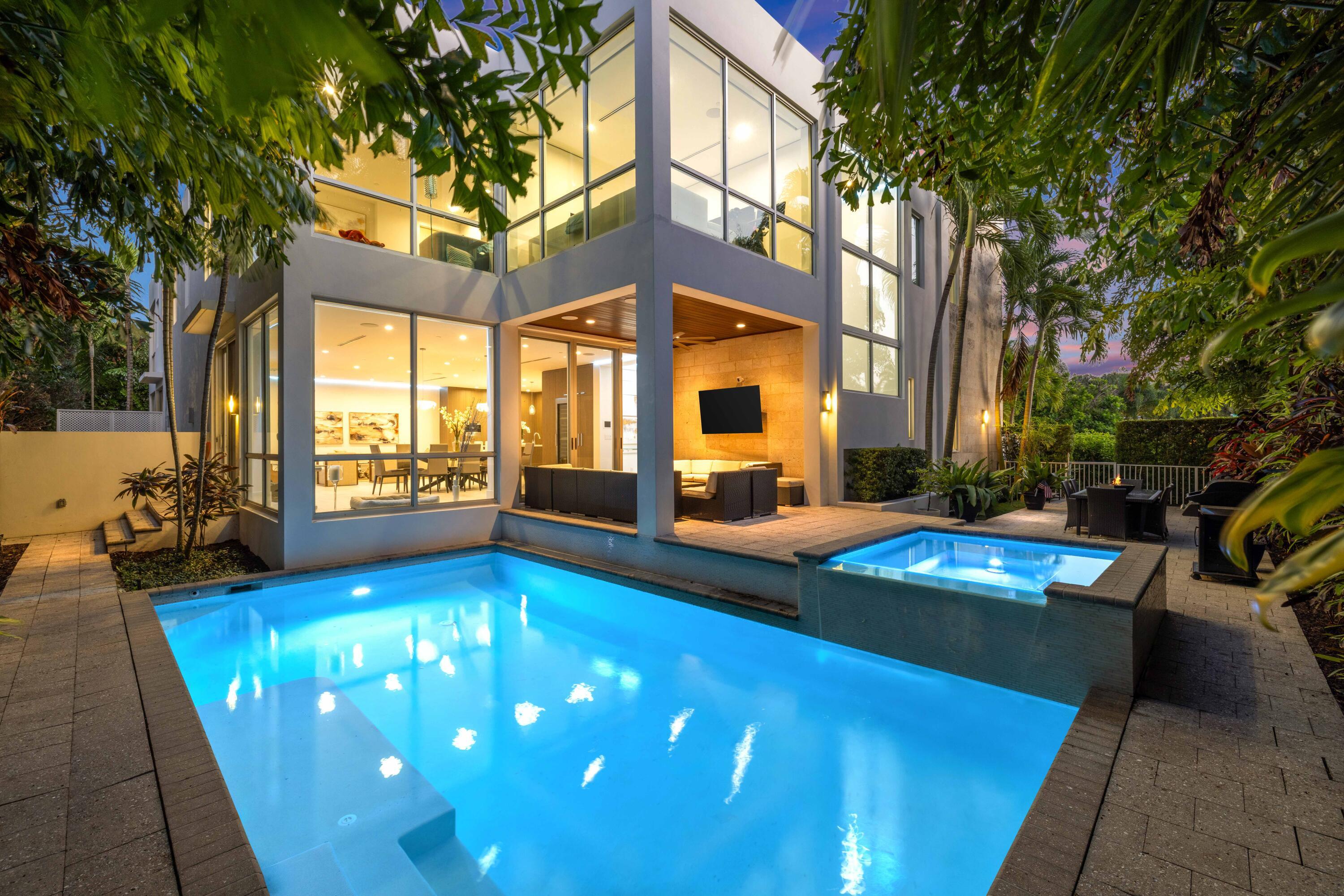 Modern corner-lot home built by JH Norman and designed by George Brewer Architects, with soaring ceilings, walls of glass, and a seamless indoor-outdoor flow to a pool, spa, and lush mature landscaping. The open kitchen features Miele appliances, a dramatic oversized island, and wine storage. A main-level flexible room, upstairs en-suite bedrooms, spa-inspired primary suite, three-car garage, and elevator complete this private, refined retreat. Light-filled interiors, generous entertaining spaces, and thoughtfully designed layouts combine with privacy and modern design, just steps from the beach and moments from Atlantic Avenue, offering effortless coastal living in one of Delray Beach's most coveted neighborhoods. An additional room on the main level provides flexibility for a   home office, media room, or guest suite. Upstairs, all bedrooms feature en-suite bathrooms, and the primary suite serves as a private retreat with a spa-inspired bathroom that complements the home's modern design. Additional features include a three-car garage, thoughtful storage, and a layout that supports easy day-to-day living. Just moments from Atlantic Avenue's dining, shopping, galleries, Green Market, live music venues, and nightlife, this home allows you to enjoy the energy of downtown Delray while returning to the quiet character of one of the area's most established beachside neighborhoods.