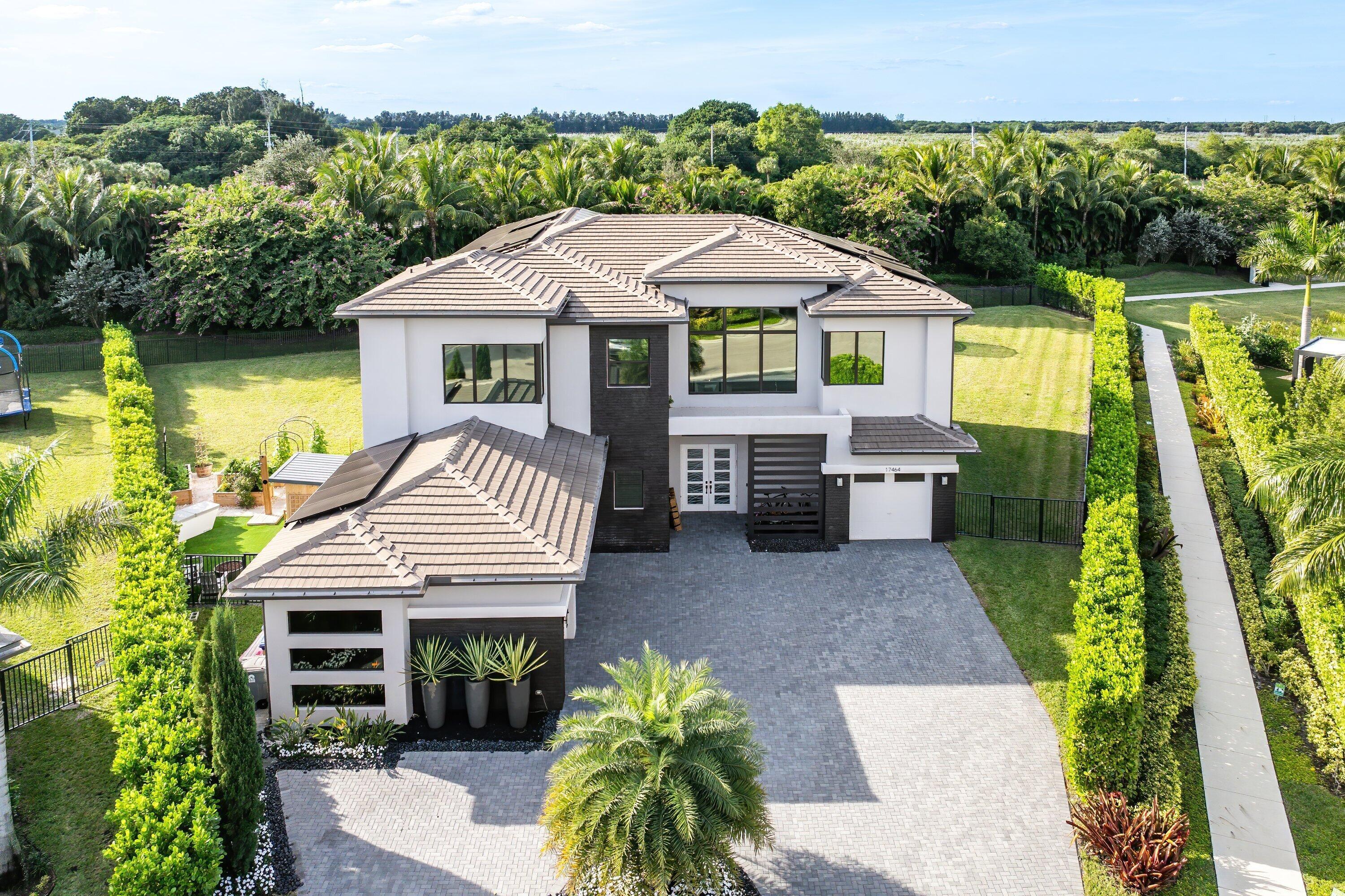 Nestled behind the prestigious gates of Boca Bridges, this 6 bedroom contemporary Palermo is ideally situated at the end of a cul-de-sac on over half an acre of expansive property. This stunning estate spans over 6,000 sf of exquisitely decorated living space and features a living room with built-in bar and marble fireplace, custom ceilings, beautiful built-in closets, Tesla solar panels with Powerwall backup batteries and a spectacular chef's kitchen inclusive of a walk in pantry and Sub-Zero/Wolf appliances. The sprawling backyard oasis hosts a heated, saltwater pool and summer kitchen. Luxury living is redefined at Boca Bridges where residents have access to resort amenities inclusive of a restaurant, beach entry pool, kids splash park, fitness center, tennis and pickleball courts.