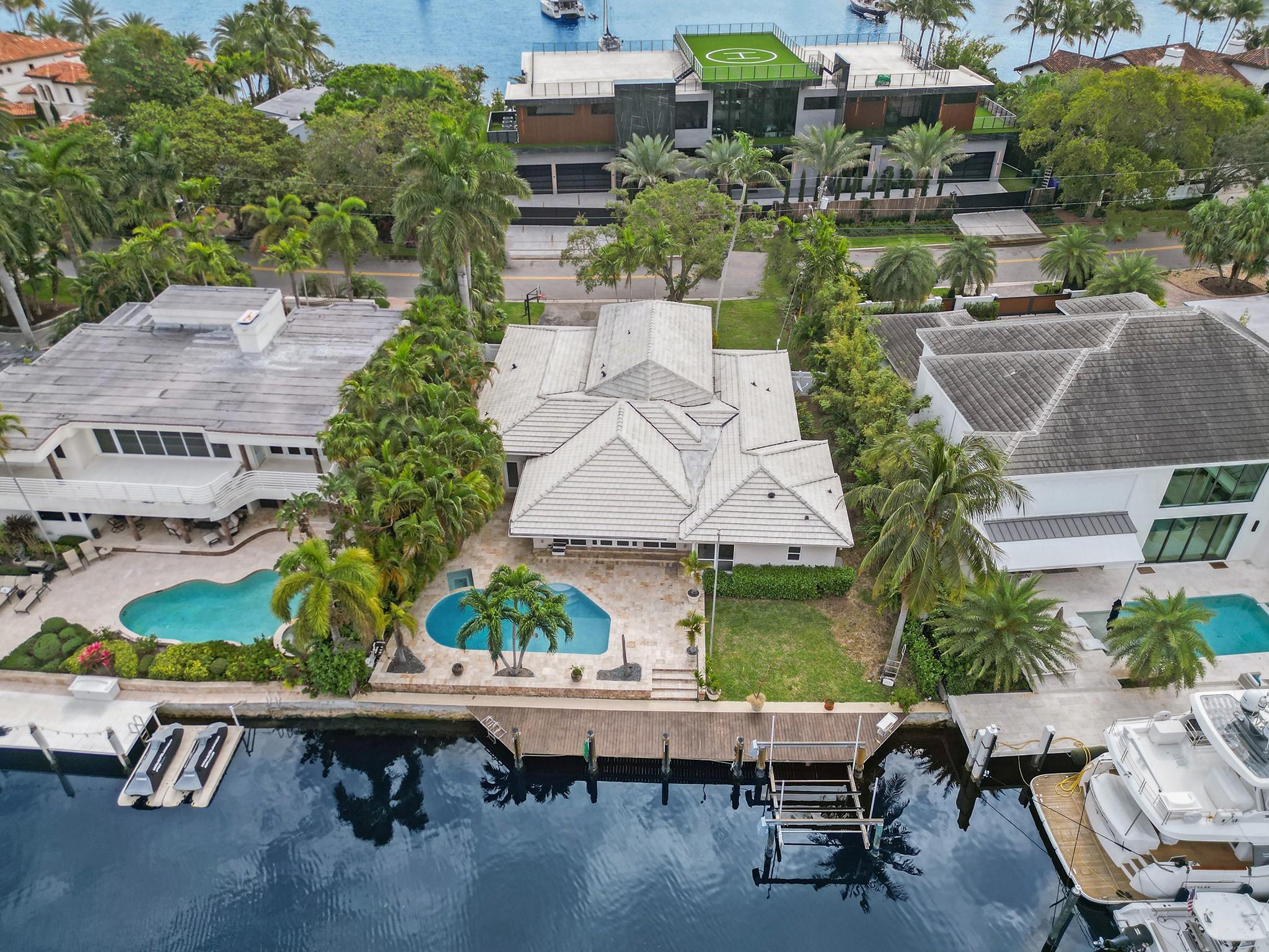 Discover Luxury in this Fully remodeled 4 bed/4 bath Waterfront haven. Boasting 87 FT of waterfront & a boat lift-equipped dock, this Home captivates an open-concept split floor plan ensuring optimal privacy! Panoramic water views adorn the Main bedroom, Living room, & Kitchen! This Residence is enhanced by lavish stone & porcelain flooring, along with recessed lighting. Chef's kitchen showcases quartz countertops, a Subzero refrigerator, & a Wolf gas range. Situated on a Serene cul-de-sac with a One Way Entry & Exit, conveniently close to the beach, mall, shops, all within walking distance. Revel in the convenience of the best school zones, a fenced-in backyard, a spacious garage, & the absence of HOA restrictions. This residence seamlessly blends modern aesthetics with waterfront allure.