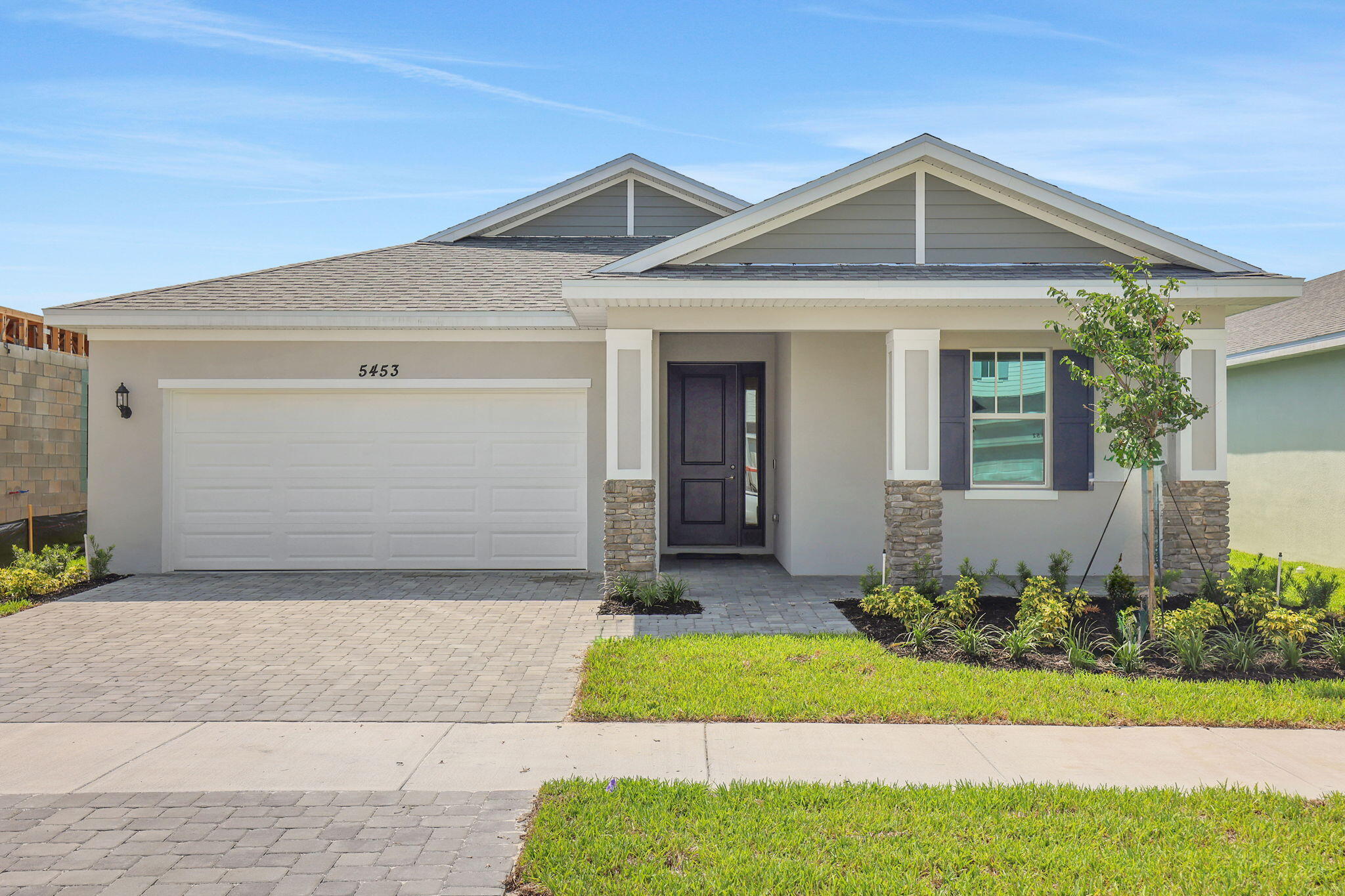 Showcasing the Mulberry, Elevation C, a beautifully designed new construction home in Brystol North at Wylder in Port Saint Lucie, ideally situated on Lot 13 with a charming front porch elevation and a private 50-foot homesite. This spacious 4-bedroom, 2-bathroom home offers a well-designed layout with a 2-car garage, blending comfort, style, and functionality for modern living.  The open-concept floor plan creates a seamless connection between the kitchen, dining, and great room, making it perfect for both entertaining and everyday life. The kitchen features quality cabinetry, granite countertops, stainless steel appliances, and a spacious island that serves as the heart of the home.