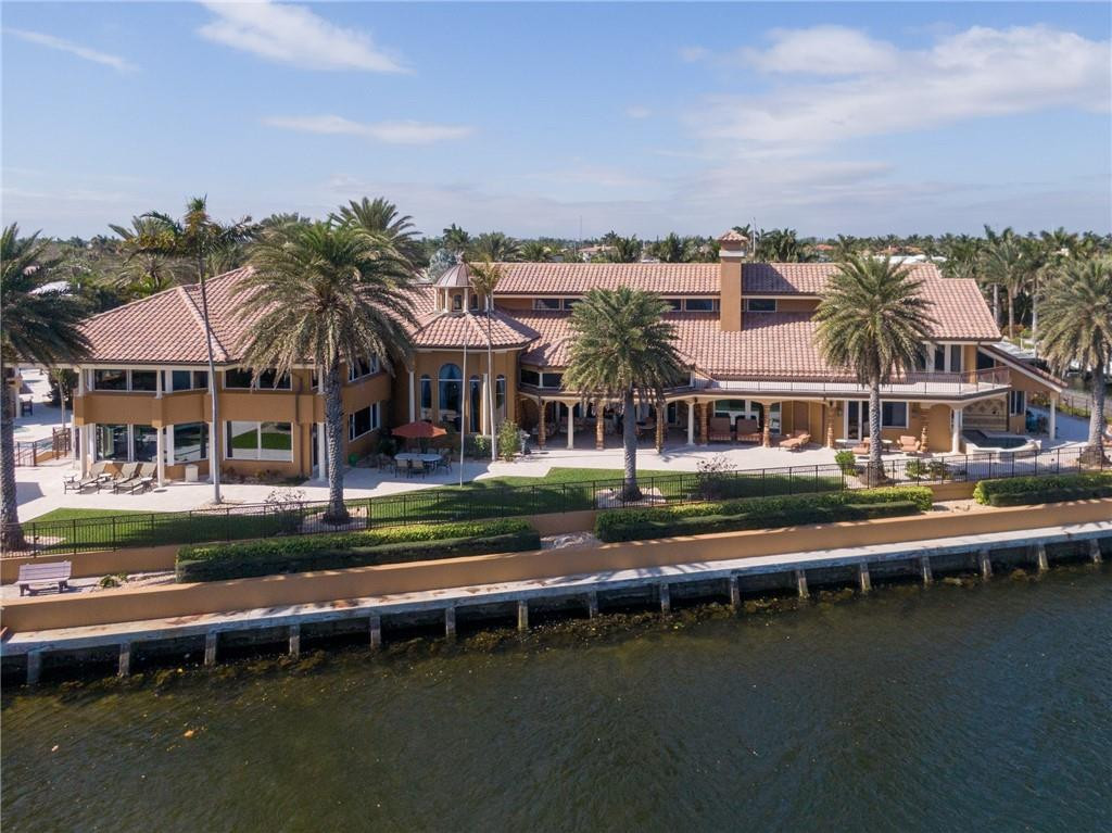 Exquisite oversized estate consisting of 5 full lots/1.63 acres located on the intercostal with 465 feet of deep water frontage and just minutes to the ocean by boat! This 16,693 square foot luxurious mansion includes impeccable views, 8 bedrooms and 8/2 baths, an oversized master bedroom wing with its own outdoor jacuzzi, resort style pool and jacuzzi, sand volleyball court, basketball & tennis court, pavilion with summer kitchen, pool house studio, indoor & outdoor exercise rooms, office, elevator, bar, billiard room, multiple living rooms, side garden with mango, banana and papaya trees, detached 1 bedroom guest apartment or nanny courters and a 6 car garage. This home is incomparable to any other home in Lighthouse Point!