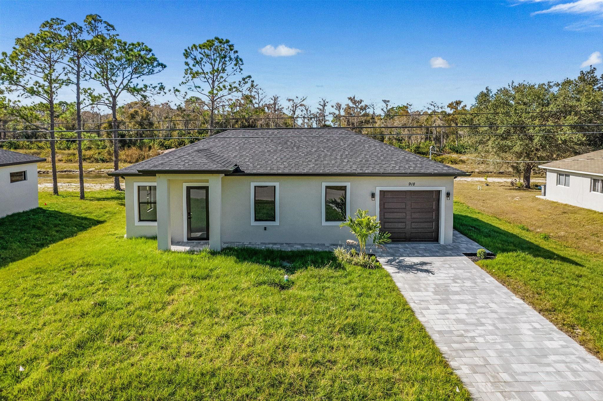 Brand-new construction *MOVE IN READY NEW DREAM HOME **Seller Willing to offer up to $10,000 toward buyer's closing costs** - Be the 1st to live in this Gorgeous 3 Bedroom, 2 Bath Home with Garage, on a Spacious canal front lot. **Oversized luxury tile flooring throughout every room with Impact-rated windows for you to enjoy the amazing Florida Sunshine! The Modern LUXE Kitchen has custom cabinetry, quartz countertops, & stainless-steel appliances. Spacious Bathrooms feature Beautiful modern cabinetry, roomy showers..Like a spa! This HOME sits on a rare quarter-acre lot & offers great outdoor space...A Great Location & neighborhood to enjoy, with NO Homeowners Association/HOA **Your NEW FLORIDA HOME just one call away..