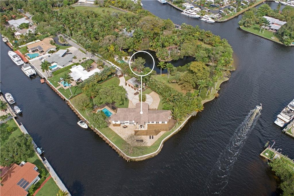421 Ft Of Deep Waterfront Ideal For The Avid Yachtsman looking to dock a large or multiple vessels. Gated & secured estate, a point lot comprised of almost 1 full acre on the New River, no fixed bridges & across from the protected Secret Woods Nature Center. Experience the S. Florida tropical dream with breathtaking waterway views, multiple outdoor living spaces, a heated pool & spa, an oversized patio area, lanai & tremendous green space with lush foliage. This contemporary estate features an open design, soaring ceilings, a media room & gourmet kitchen opening to a large family room. The enormous primary bedroom boasts unparalleled views of the waterway, private access to the pool & spa, a seating area, spacious dressing area with custom closets & lavish bathroom. Sq ft from BCPA