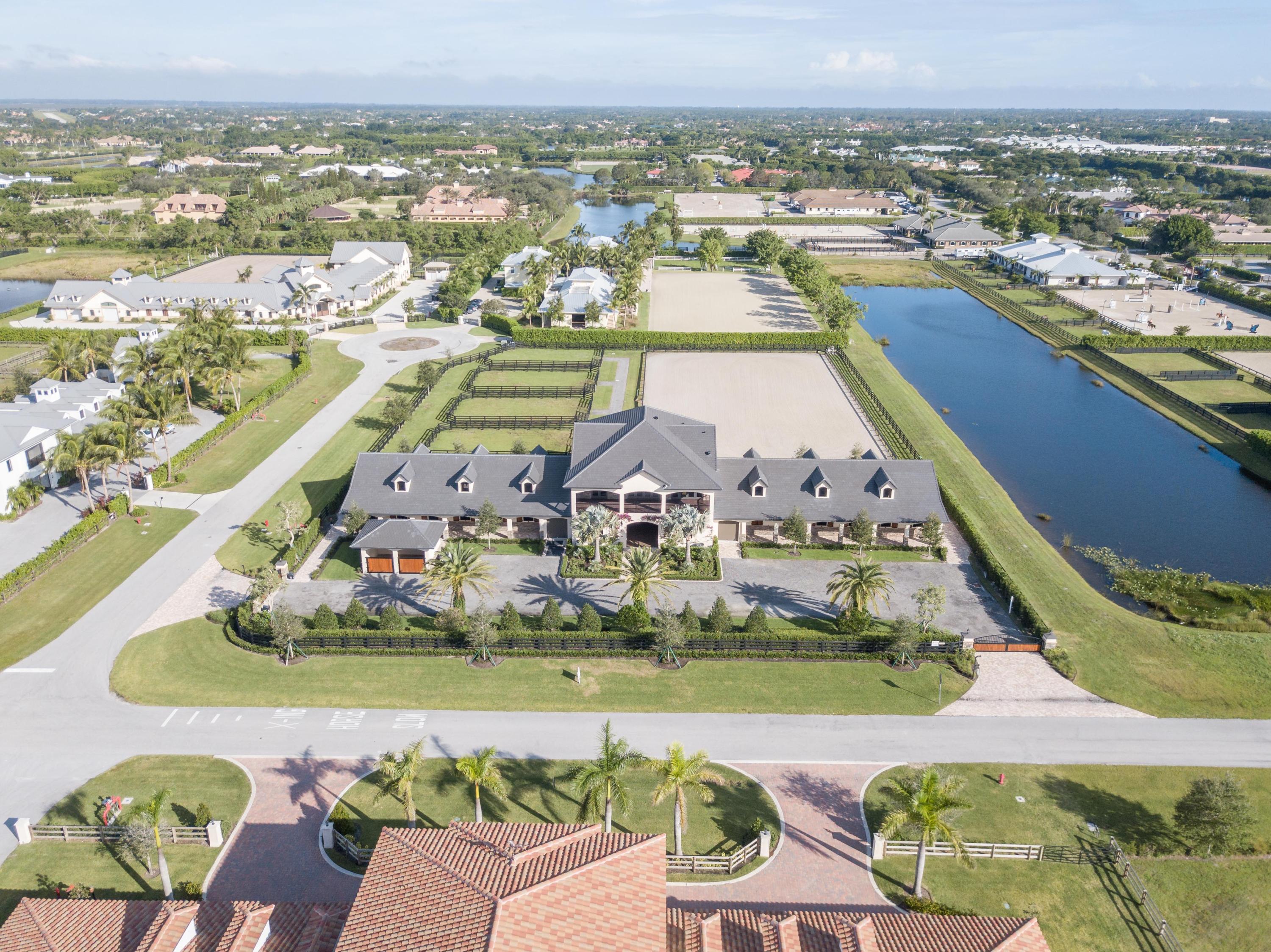 Exquisite new construction in the beautiful Grand Prix Village South neighborhood situated on 4 acres of well maintained land. This property was planned to be every equestrian's dream. The 20-stall center aisle barn is fresh and functional with four wash stalls, tack and feed rooms, a laundry room, an office, lounge, and a full bath. The second story of the barn serves as a refined space for relaxation. The owners' quarters include three bedrooms, three bathrooms, an open kitchen, and spacious living areas. The wrap around porch is not to be missed - nor are the breathtaking views of the property. The grounds include 4 paddocks and a sand arena. Close to PBIEC, this immaculate property is move-in ready for season. Be sure not to miss this truly unique custom barn by designer Joyce Bashein.