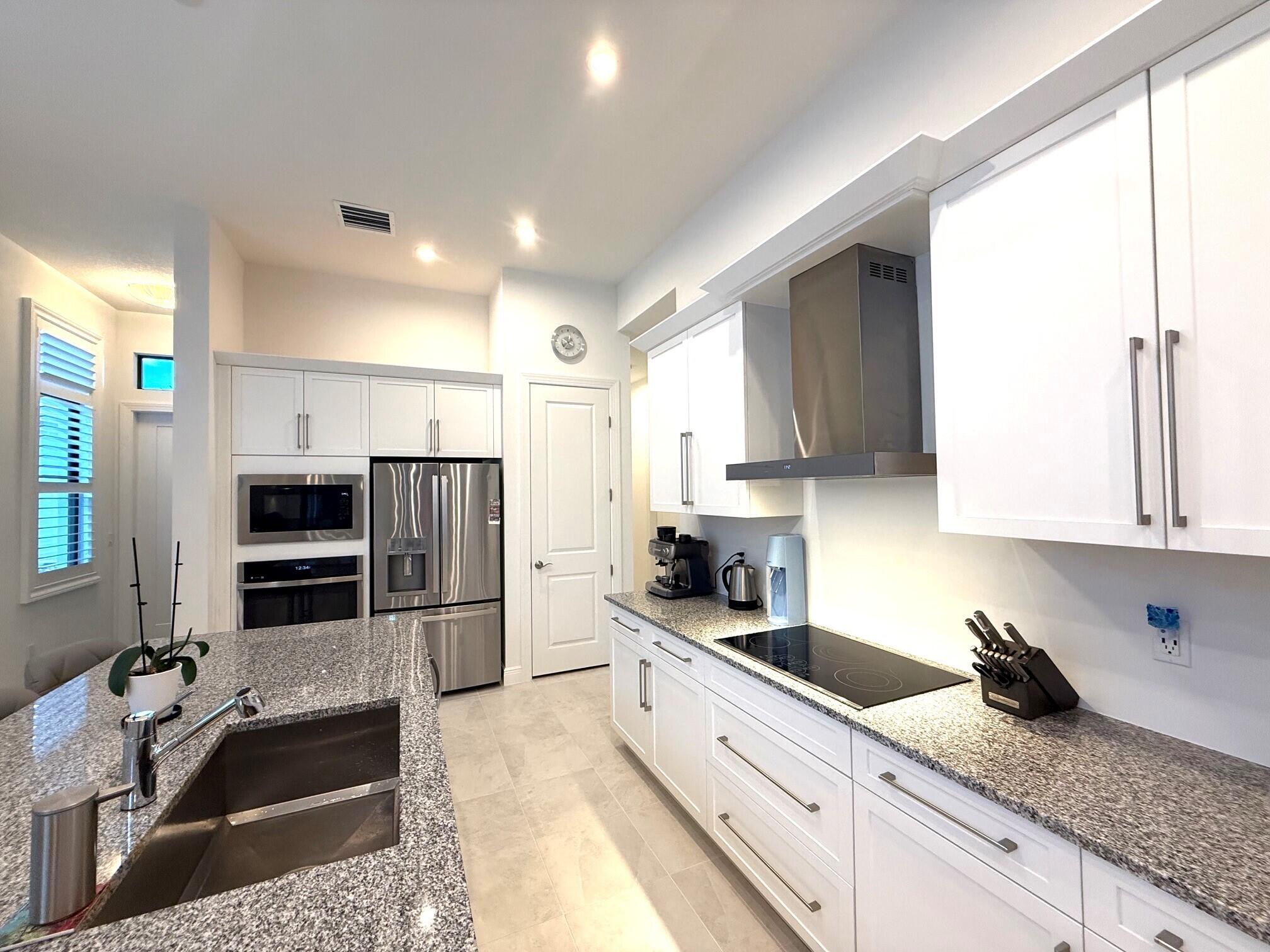 Better than new and vacant! Lightly lived in (approx. 8 months) with extensive post builder upgrades, this 3BR + den home features 11'4" ceilings, 10' x 12' sliding doors, and a private preserve view. The gourmet kitchen includes a large island, GE Profile Smart appliances, upgraded hood, 42" cabinets, and a multifunction smart oven. Impact windows throughout. All windows feature privacy tint film providing 70-80% heat reduction and 99% UV protection. Custom plantation shutters with 4.5" louvers. Additional upgrades include whole house gutters, French drainage, epoxy garage floor, extra exterior lighting, upgraded landscaping, privacy wall, fruit trees (banana), high TV mounts, and smart large washer/dryer. Located in Rivella, a gated community with gym, pool, tennis courts, low HOA.