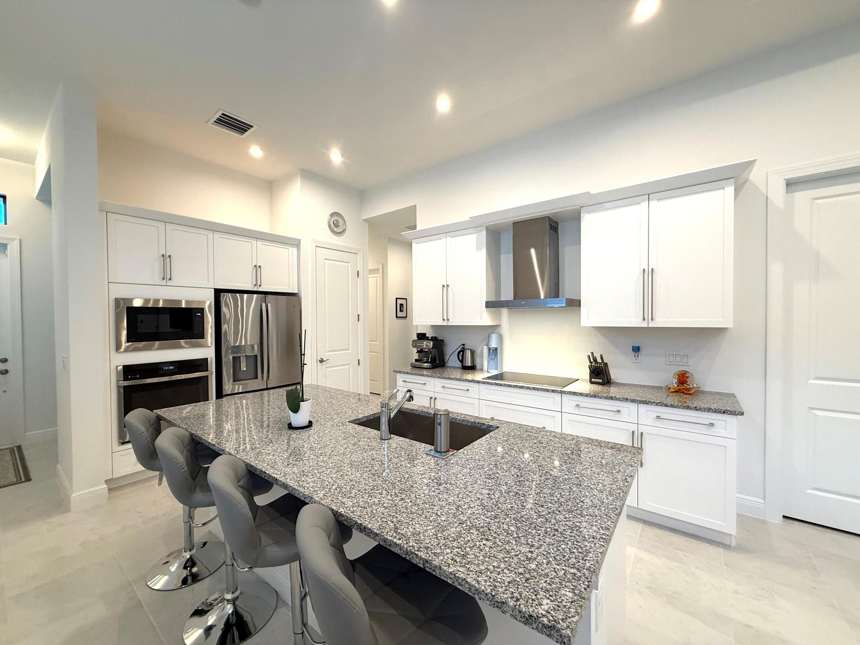 Better than new and vacant! Lightly lived in (approx. 8 months) with extensive post builder upgrades, this 3BR + den home features 11'4" ceilings, 10' x 12' sliding doors, and a private preserve view. The gourmet kitchen includes a large island, GE Profile Smart appliances, upgraded hood, 42" cabinets, and a multifunction smart oven. Impact windows throughout. All windows feature privacy tint film providing 70-80% heat reduction and 99% UV protection. Custom plantation shutters with 4.5" louvers. Additional upgrades include whole house gutters, French drainage, epoxy garage floor, extra exterior lighting, upgraded landscaping, privacy wall, fruit trees (banana), high TV mounts, and smart large washer/dryer. Located in Rivella, a gated community with gym, pool, tennis courts, low HOA.