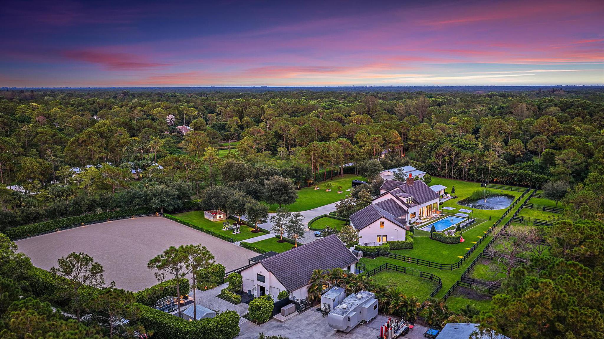 This completely reimagined estate combines timeless charm with modern luxury on 5 private acres in Palm Beach Gardens' coveted equestrian community of Caloosa. Designed as a full retreat, it offers open, sun-filled living spaces and resort quality amenities inside and out.

Walls of windows frame the flowing layout, connecting the designer kitchen, dining area, and inviting living spaces. The primary suite features a morning bar, custom wardrobe closets, and a spa-style bath. Multiple guest suites and a luxury in-home cinema provide space for everyone to unwind.

A fully automated Control4 smart home system with Josh AI manages lighting, climate, entertainment, and security, delivering convenience to match the estate's beauty. Every detail has already been thought through - even electronic shades are installed on all windows, unlike many new-construction homes where you'll still need to add window treatments, security, and smart features. This home is truly move-in ready, offering a complete luxury experience from day one.

The backyard is an entertainer's dream with a lap pool with heater and chiller, turf lounging areas, fireplace, covered summer kitchen & bar, Coastal Source audio, and full landscape lighting.

Equestrian facilities include an 8-stall Wellington-style barn, full-size riding arena, multiple paddocks, and a separate gated entrance. 

A massive 2762 sqft. detached building houses car and toys storage, a space for a gym and office, and a man cave, while a finished she-shack serves as an ideal home office. Additional amenities include a pole barn, 1,500-gallon buried propane tank, 500-gallon gas and 500-gallon diesel fill-up station, whole-house generator, mature privacy hedging, and professional landscaping throughout. 

Finished with craftsmanship and detail often seen in $15M+ Palm Beach Island estates, this property offers elegance, privacy, and functionality. Caloosa features 30 miles of riding trails, a 32-acre equestrian park, and a location just minutes from the best of Palm Beach Gardens-yet this home has everything you need without ever leaving.
