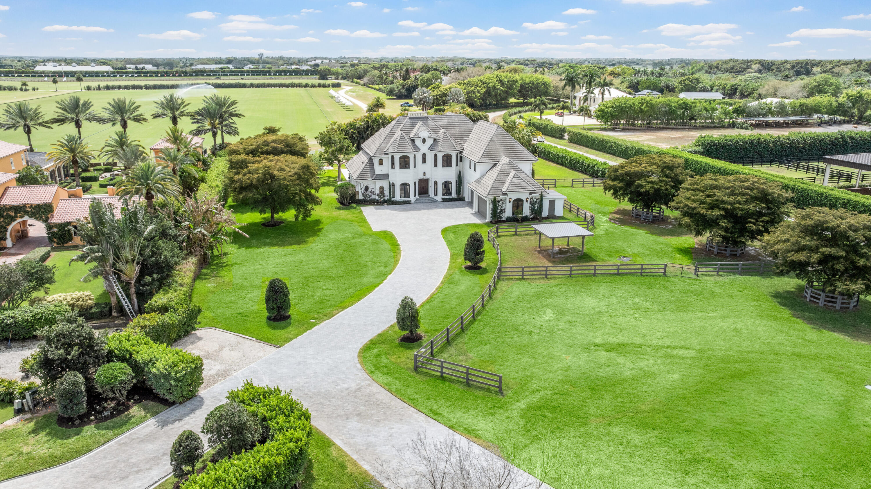 Experience the exceptional lifestyle offered by this private family compound, featuring a spacious 4 bedroom main residence and a newly constructed 3 bedroom, 2,800 sq. ft. carriage house, ideally situated in the prestigious Southfields community in the heart of Wellington. This prime location places you just minutes from all major equestrian and polo venues, with the property overlooking the renowned Grand Champions Polo Club fields, where you can enjoy afternoon matches from the comfort of home. Main Residence The main house offers a generous and thoughtfully designed layout. The first floor primary suite provides convenience and privacy. The second floor features a dedicated theater and game room, perfect for entertainment, along with three additional bedrooms, including  (see remarks)  junior suite with a private balcony showcasing sweeping polo field views. A 4 car garage provides ample storage for vehicles, equipment, and lifestyle needs. Step outside to a large resort style pool area, ideal for entertaining, relaxing, and enjoying unobstructed views of the polo fields. Equestrian Features For equestrian enthusiasts, the property includes: Paddocks Wash racks Space to construct a 4 stall barn, offering the opportunity to customize your ideal setup. Carriage House The newly built 3 bedroom carriage house features: An open concept floor plan High end finishes throughout A 2 car garage Modern design and exceptional craftsmanship, perfect for guests, staff, or extended family.