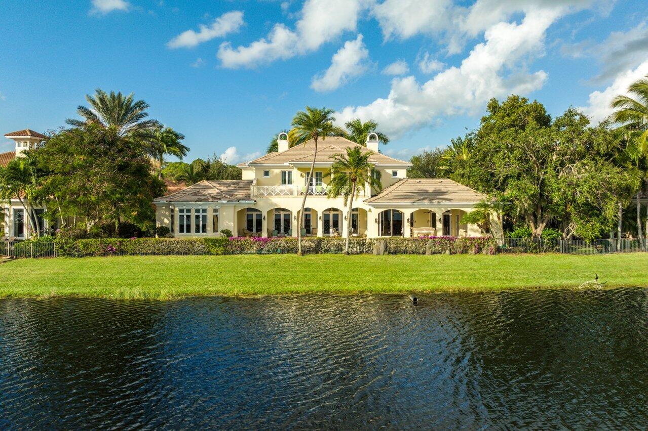 Magnificent, one-of-a-kind, nearly 8,000 square foot Bermuda style custom estate in the prestigious Palacio community of Mirasol, offers long and wide lake views, 6 bedrooms, 7 full baths, 2 half baths, a private theater, wine cellar, elevator and custom his and her office. A spacious motor court with 3 car and golf cart garages leads to a grand entrance through double wood doors. Enter into luxury and elegance, expressed through marble flooring with onyx inlays and a wood and wrought iron circular staircase. A custom fireplace, crown moldings, exceptional ceiling detail, millwork and lighting fixtures are masterfully placed throughout for exquisite architectural detail. Gourmet kitchen fit for professionals, with 6 burner gas range, 3 ovens, vegetable sink with refrigerator drawers in center island and top of the line appliances, including 2 dishwashers. A wood beamed ceiling, rich granite counter tops and counter seating complete this special room. The elegant dining room has artistic ceiling detail, columns and a beautifully designed onyx patterned floor. Relax in custom family room with deep toned wood ceiling beaming and large matching built-in. The outdoors truly comes inside with a unique wall of hide-away pocket sliding doors. Beautiful office fully fitted in exquisite woods with exceptional shelving and built-ins. Private theatre with extensive detailed millwork has custom built-in entertainment systems and two-tiered flooring. Spectacular master bedroom with wet bar and microwave and his and hers walk-in closets with custom shelves and dressers. Exceptionally appointed his and her baths with over-sized frameless shower, whirlpool tub, dual vanities and custom cabinetry. An adjoining sitting room or second office, also with beautiful cabinetry, has doors leading to the patio and pool to complete this expansive master suite. A private, luxurious guest bedroom and bath with morning kitchen can also be found on the main level. Ascend the beautiful wooden staircase to the loft and 4 additional bedrooms, each with full baths, personal A/C zones and French doors to terraced balconies. Unparalleled outdoor area, with complete privacy provided by mature landscaping, a large covered loggia with full summer kitchen, exceptional architectural detail and large pool with Jacuzzi, make this estate an absolute must to see!