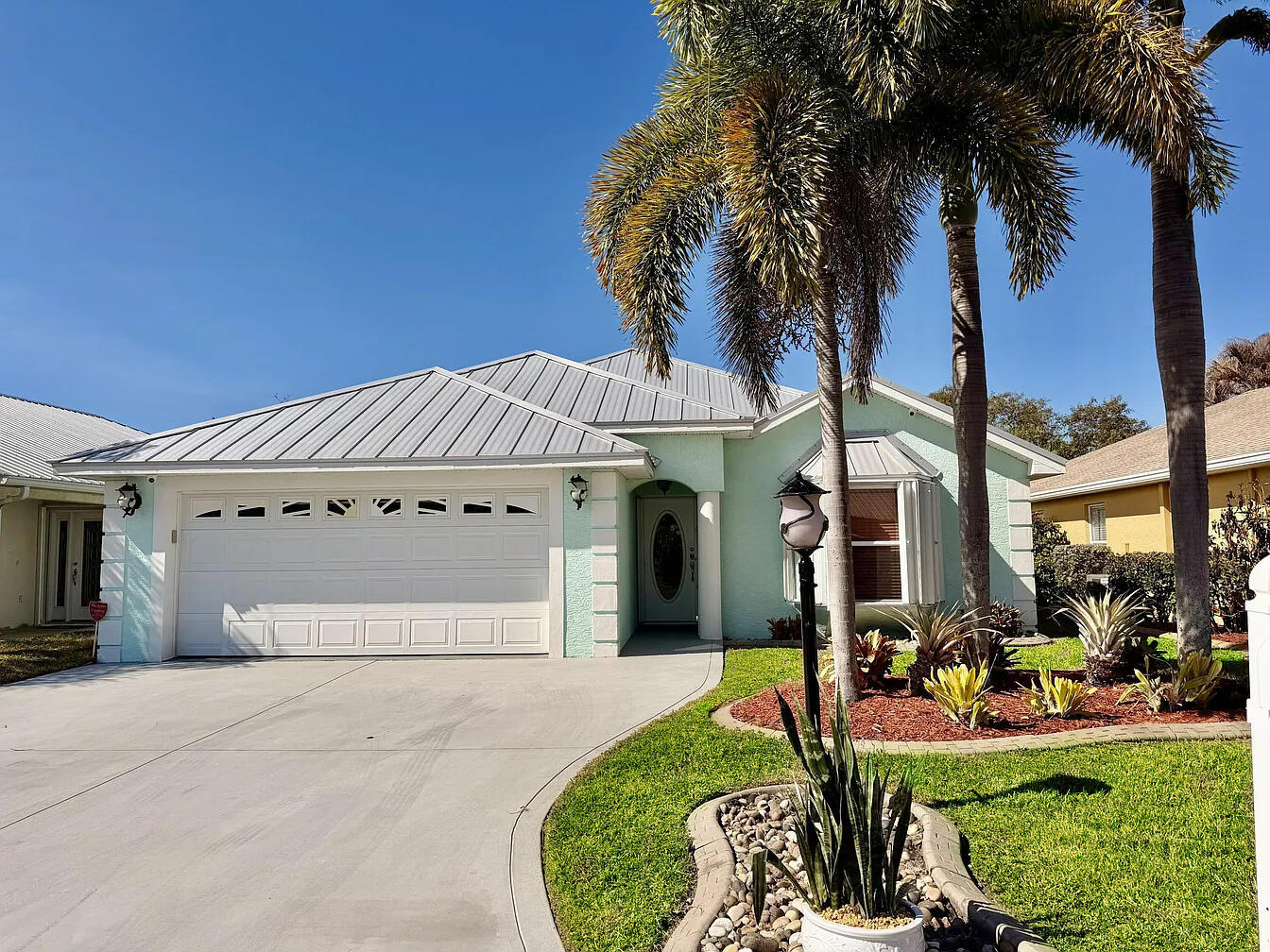 PALM CREEK - Exquisite PERFECTION! Lake Access home in Gated Community. 3 Bd/2ba/2CG - CBS/Stucco.  Lovely details include Travertine tile floors, custom cabinets, travertine counters and backsplash.  This kitchen shines with cathedral cabinets, stain glass display doors, lazy Susan, coffee bar and pantry.  Foyer and Formal Living room.  14 x 14 Den w/water view for relaxing.  The 14 x 40 full length screened lanai w/custom shades, offers lazy days or light hearted entertaining.  The Seawall and covered boat dock invites afternoon sailings to Taylor Creek and Lake "O".  Metal Roof, Accordian Storm Shutters, Safe Room and CCTV Camera system.  Make this dream home your forever home!