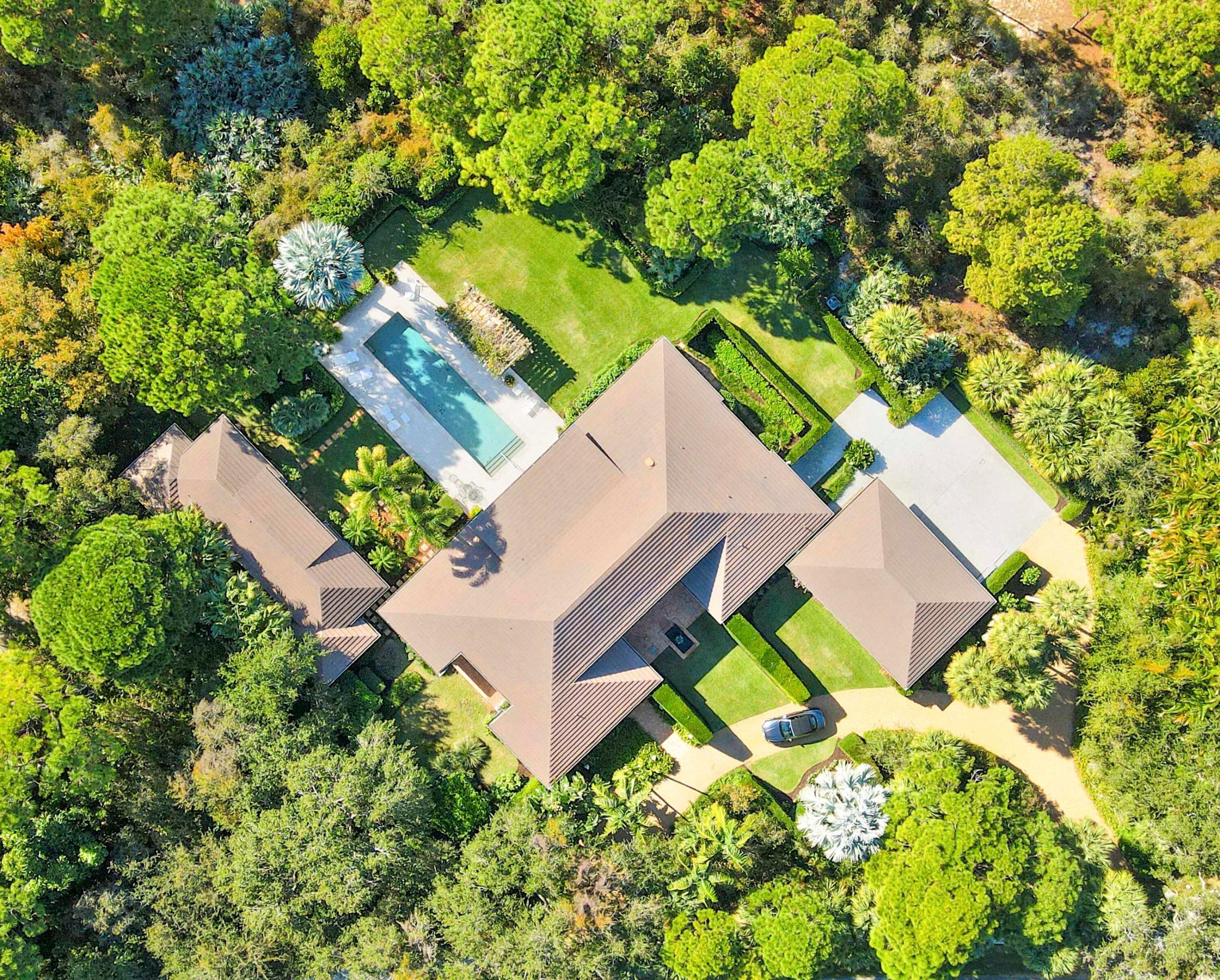 Situated on an expansive double lot totaling 1.37 acres, this inviting property offers privacy, flexibility, and room to enjoy outdoor living. The main residence features two bedrooms and two-and-a-half baths, with hardwood floors throughout the main living areas and soaring volume ceilings that enhance the bright, open great room. A screened, covered loggia overlooks the pool, creating a seamless indoor-outdoor living experience ideal for relaxing or entertaining. A detached guest house adds exceptional versatility, offering two bedrooms and two full baths, perfect for hosting guests, extended family, or creating a private work-from-home retreat. With generous living spaces, a resort-style pool, and a rare oversized lot, this property presents a unique opportunity to enjoy comfort, space