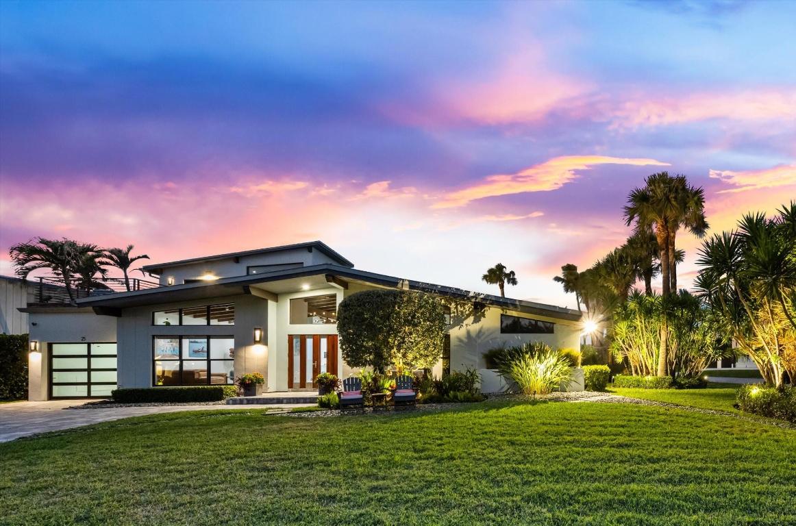 Located in the exclusive seaside community of Jupiter Inlet Colony, this rare midcentury modern home sits on a desirable interior corner lot at the southern tip of Jupiter Island, offering beautiful views of both the Atlantic Ocean and the Jupiter Inlet. Just steps from the community beach access and across from the private beach club, the setting delivers an effortless coastal lifestyle with exceptional privacy and security.
The furnished three-bedroom, three-bath residence has been thoughtfully remodeled and meticulously maintained. Interior highlights include volume ceilings with exposed beams, impact windows and doors, custom lighting, Brazilian walnut and porcelain floors, and a modern kitchen equipped with Thermador appliances. The spacious primary suite features a large bedroom with a spa-style bath with a soaking tub and separate shower.
Private outdoor living areas with lush landscaping are designed for relaxed island living, with a screened patio, splash pool, outdoor shower, putting green, as well as an Ipe mahogany deck ideal for enjoying ocean breezes, sunrise coffee, and sunset evenings. With its own police force and quiet, well-managed atmosphere, Jupiter Inlet Colony offers a rare combination of luxury, tranquility, and beachfront living.