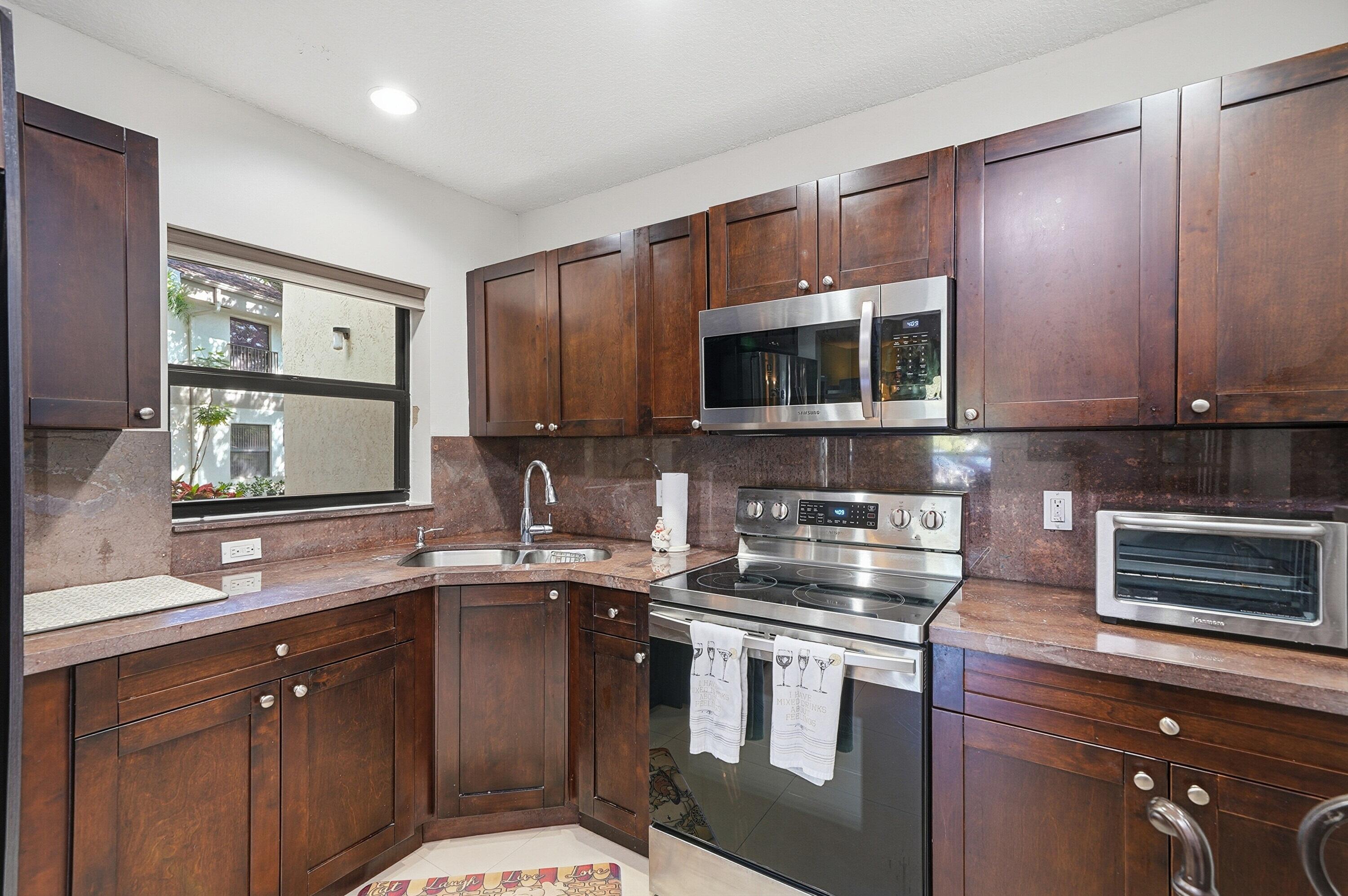 Beautifully updated unit featuring a clean, modern finish with no popcorn ceilings and elegant 24x24 tile flooring throughout. The kitchen is appointed with rich mahogany shaker cabinets, granite countertops, and stainless steel appliances, offering both style and functionality. Major upgrades completed in 2021 include all hurricane impact doors and windows, a new electrical panel, as well as a new A/C system and water heater for peace of mind.  This well-maintained, owner-occupied community does not allow rentals and requires a minimum of 12% down per HOA guidelines, with a solid budget in place. The unit also comes with a conveniently located parking space nearby, adding to the overall ease and comfort of living.