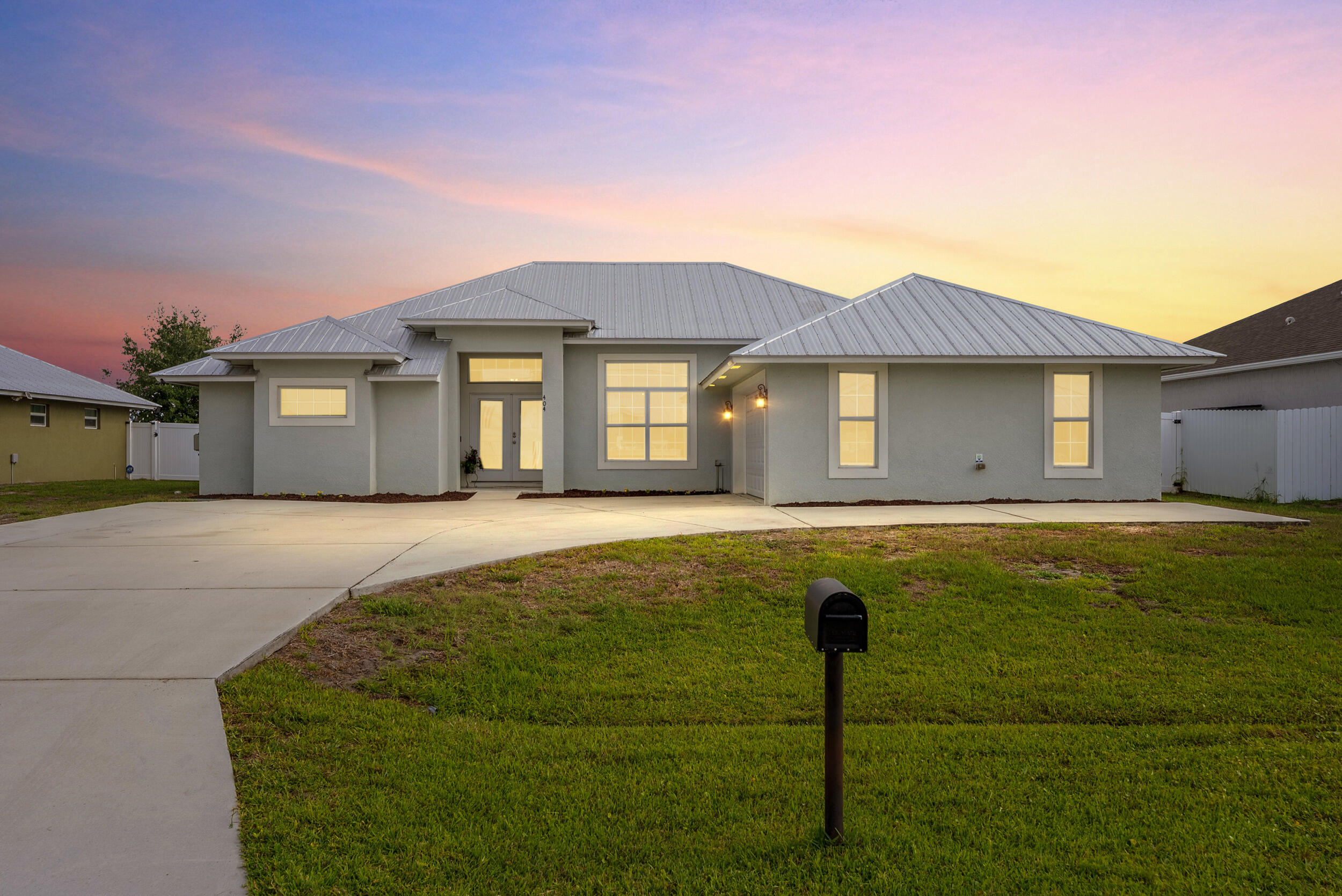 Why wait to build when this house has it all?  Built in 2021, this spacious & beautiful Modern Farmhouse CBS home features Metal Roof, Hurricane Impact Windows, EV charger, Fenced Yard & wood look Tile throughout.   With over 2,000 sq ft of living space this open floor plan has room for everyone.  The gourmet kitchen features white 42" cabinets with soft close drawers, stainless steel appliances, granite countertops with a wall microwave & oven.  The primary retreat has a sitting area, double walk in closets, seperate tub & natural stone shower.  Private backyard with new white vinyl fence, covered patio & room for a pool.  Extended driveway is perfect for your boat or RV. **NO HOA** Located off Becker Road with easy access to both I-95 & Turnpike.  Close to Tradition, shopping & dining.