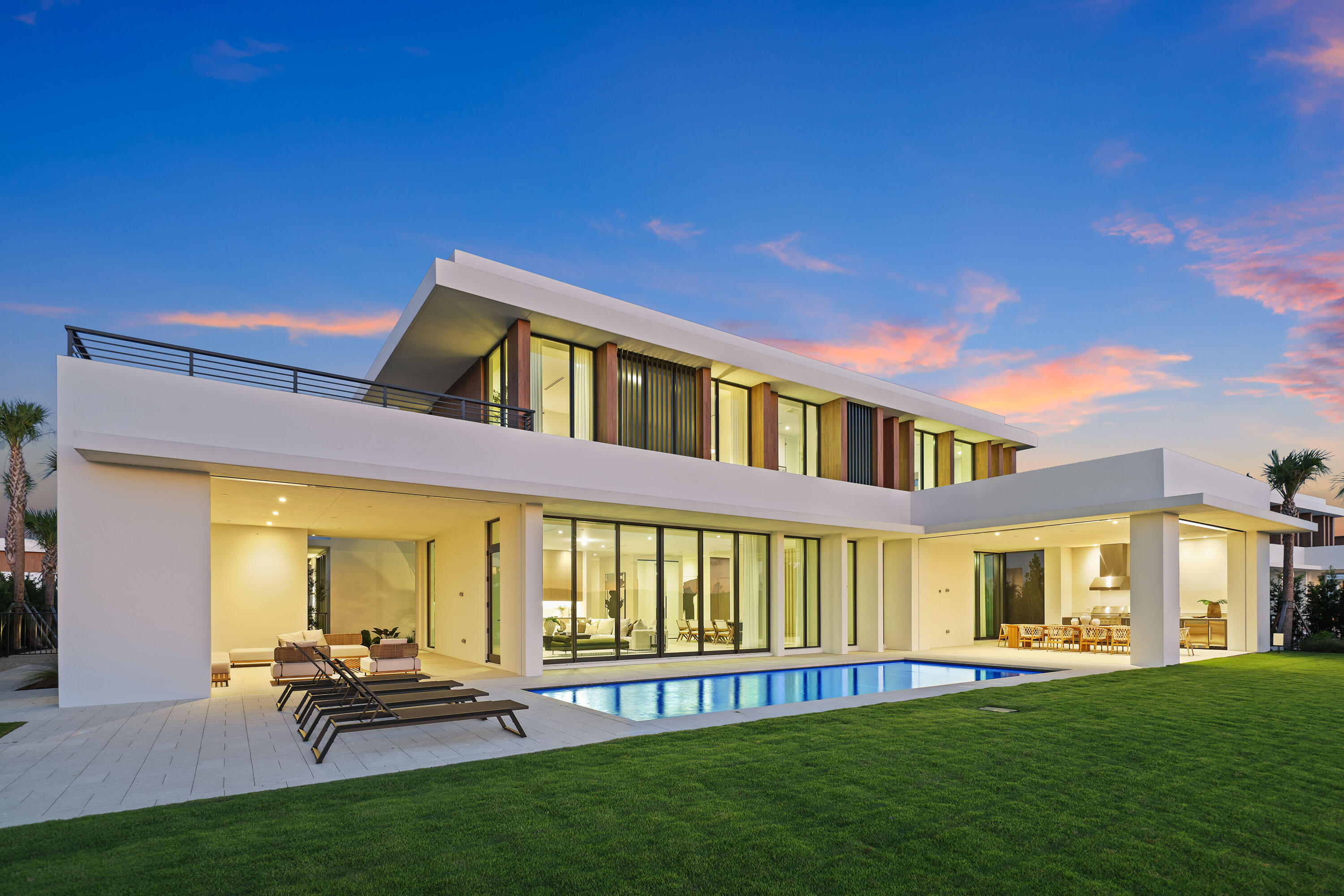 BRAND NEW, JUST COMPLETED—$400K Golf Membership Included!! This 5-bedroom, 6.5-bath estate by highly acclaimed architect Max Strang sits on a ½-acre lot in the most desirable location within Panther National, Palm Beach County's newest and most exclusive golf community. Enjoy the best views overlooking the lake, manicured greens, and spectacular sunsets. Spanning 11,023 total SF, the home offers 10'6'' ceilings, floor-to-ceiling glass, a 108-bottle wine cellar, and 2nd level loft area and wet bar. Full Smart Home automation includes Lutron lighting, solar panels, motorized screens, and automated shades. Outdoor living features multiple terraces, a summer kitchen, pool, and spa with golf and lake views. The chef's kitchen includes Wolf & Sub-Zero appliances, dual ovens, a spacious walk-in pantry, and catering kitchen. The primary suite offers dual spa-style bathrooms, dual oversized custom dressing rooms, a sitting area, and rooftop terrace. Additional features include en-suite guest rooms, an elevator, two laundry rooms, and a 4-car garage with EV charging. Residents enjoy a Nicklaus Signature Course designed by Jack Nicklaus & Justin Thomas, a state-of-the-art fitness center, resort-style pool, spa, and fine dining-luxury living in a private, modern enclave.