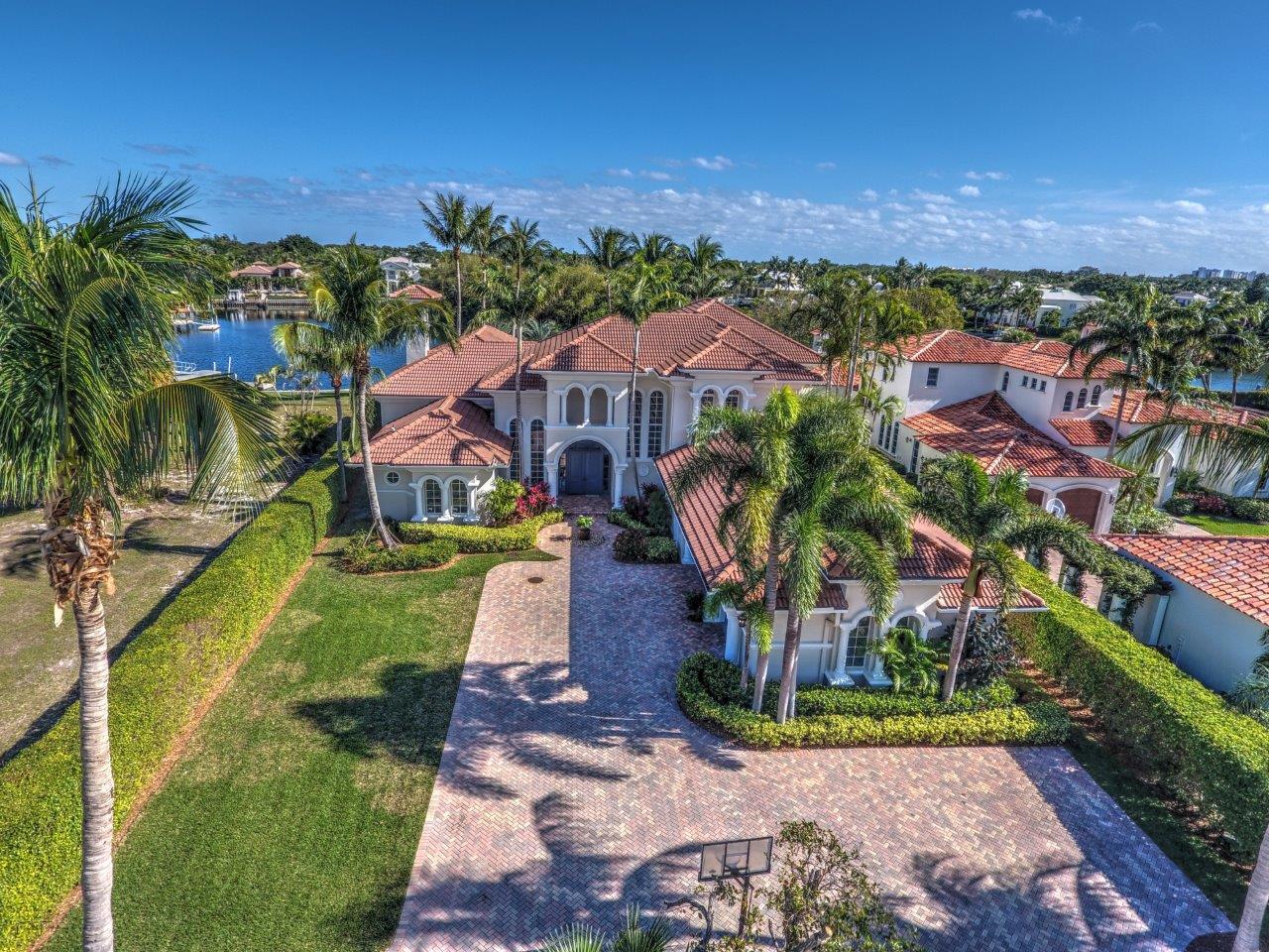 This amazing waterfront home is in the private, gated community called Captain’s Key in North Palm Beach. This Mediterranean home features five spacious bedrooms, five full recently-remodeled bathrooms, two powder rooms, and a recently-remodeled kitchen featuring Meile appliances and beautiful stone work imported from Canada.  Located on 0.65 acres, the home has eastern exposure to Little Lake Worth with easy access to the Intracoastal Waterway and the Atlantic Ocean. Sitting on 125 ft. of waterfront, the home has a dock with a boat lift that can accommodate a 35-40 foot boat. The home is perfect for entertaining with an outdoor kitchen, large gated yard, and an inviting family room. Host parties in the 30 x 50 game room complete with sunken bar, fireplace, and coffered ceiling.