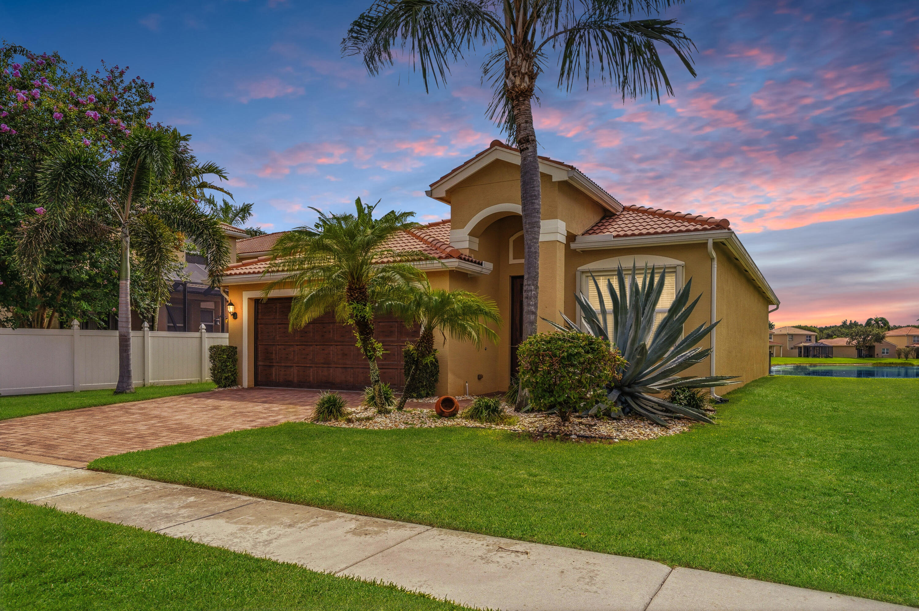 Some homes are measured in square feet. Others are measured in moments. Welcome to this beautifully maintained 3 bed, 2 bath lakefront home in Greystone, where everyday living comes with a view. The light filled, carpet free interior offers an inviting layout designed for gathering, relaxing & making memories. Step outside to the screened lanai & fenced backyard, where peaceful lake views set the scene for morning coffee & evening sunsets. Additional features include accordion shutters, a 2019 A/C & a 2 car garage. Greystone offers 24 hour manned security, a clubhouse, fitness center, resort style pool, basketball courts & more. Conveniently located near Whole Foods, multiple shopping centers, dining & the Florida Turnpike. This is more than a house. It is the backdrop for what comes next.