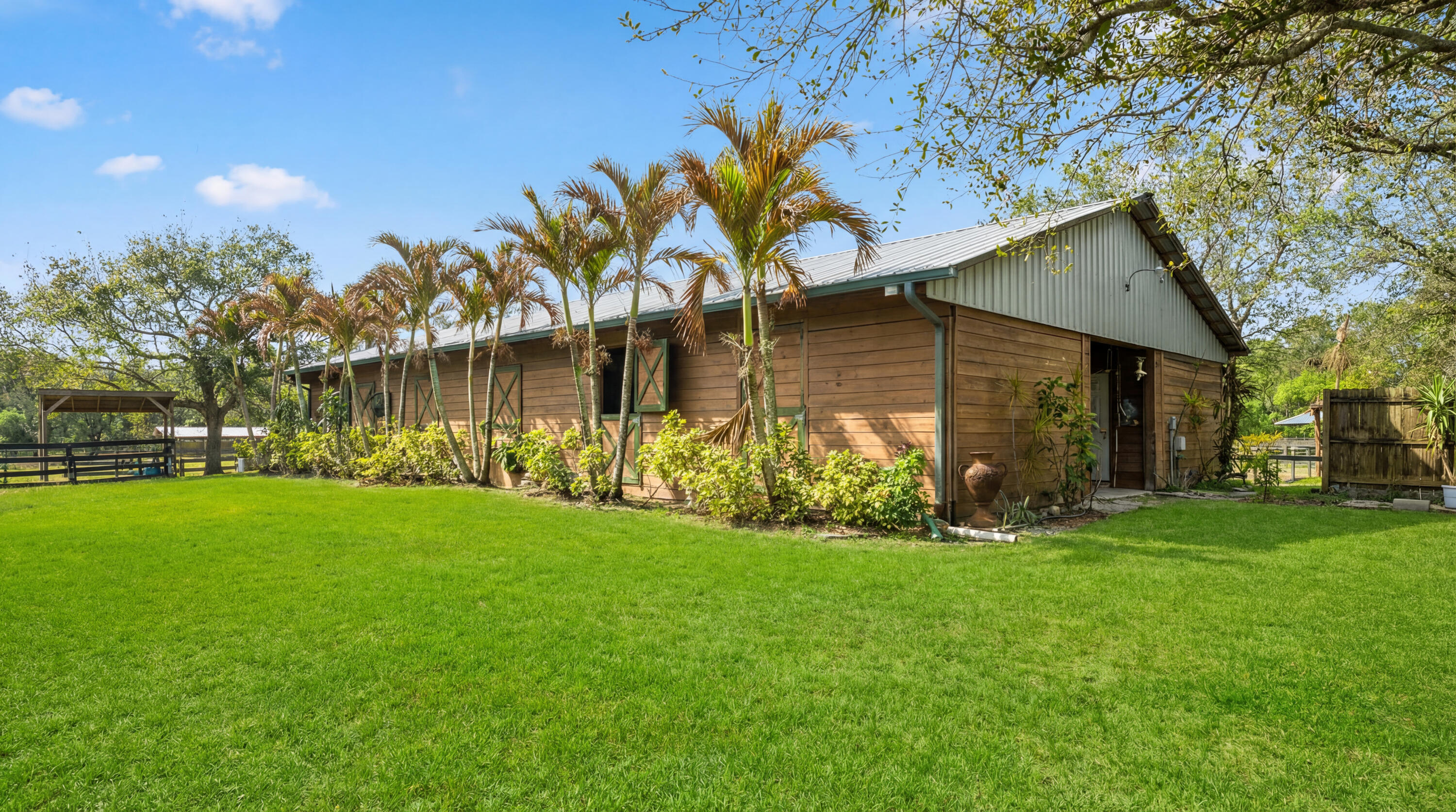 Perfect private horse farm available for rent in the Acreage! This 2014 construction barn features 7 horse stalls, two grooming stalls, two outdoor wash stalls, feed room, tack room, and client lounge. Some stalls have individual run outs. Lots of paddock space. Room for an arena. Top doors that close on all stalls and roll down hurricane doors on both ends of the barn for storm protection. RV hookups and RV available for use. This farm is on 1.97 acres on a paved road conveniently located close to all the amenities of West Palm Beach. Available for Seasonal or Annual Rental. Price reflects rental of the entire farm per month.