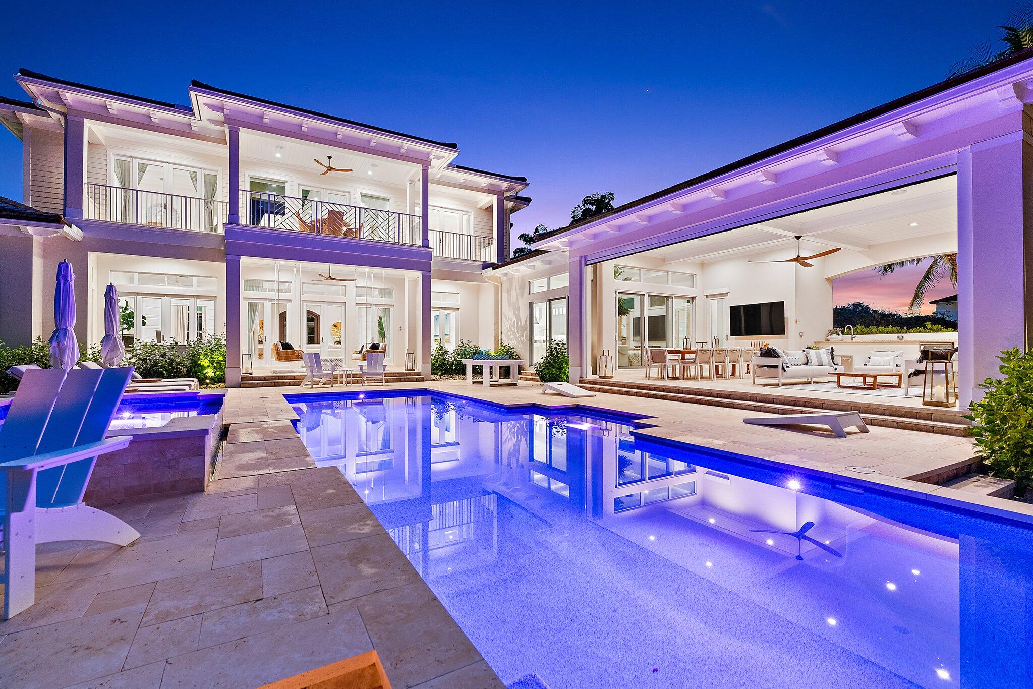 Custom waterfront estate on the scenic Loxahatchee River in Jupiter. 5-bed, 6.2-bath with 4-car garage offers 5,732 sqft of air-conditioned living plus a 1,289 sqft AC garage, and 1,354 sqft of outdoor covered areas, total of 8,375 sqft. A grand formal living area features high ceilings and French doors leading to a spacious covered and open patio and pool deck. The chef's kitchen boasts custom cabinetry, a wine cooler, and an island breakfast bar. The private owners' suite includes expansive closets and his/her bath areas, while all bedrooms are en-suite. Entertain in the spacious club room with bar area. Outdoor oasis with a covered patio, summer kitchen, and a heated pool/spa. Brand new dock with 20k lift with a second lift for jet skis and paddle boards; easy ICW and ocean access.