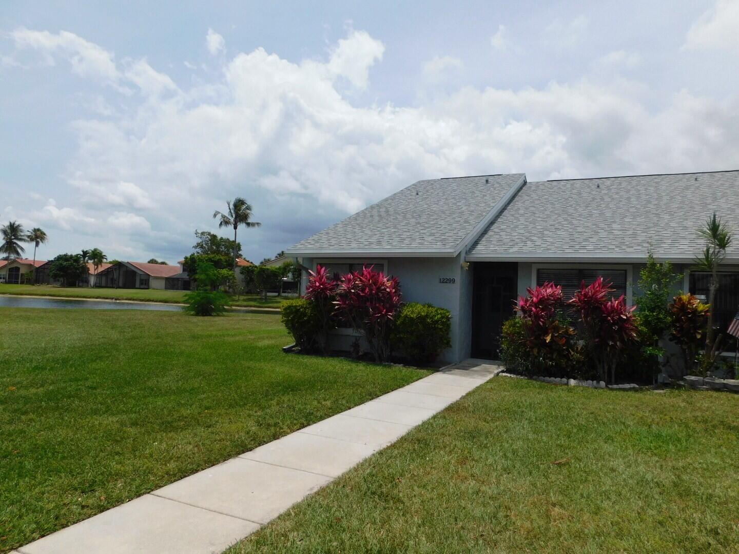 This beautifully maintained 2 bedroom, 2 bathroom villa offers serene lake views, abundant natural light, and an airy feel enhanced by vaulted ceilings. The updated kitchen features modern cabinetry and granite countertops, while both bathrooms include updated vanities with matching granite, creating a cohesive, elevated look throughout. Large windows and soaring ceilings fill the living spaces with natural light, making the home feel warm and inviting. Step outside to the screened in patio overlooking the tranquil lake — the perfect spot to relax, dine, or enjoy the peaceful surroundings. Located in a quiet, well kept community, residents enjoy access to a variety of amenities including a clubhouse, pool, bocce ball court, shuffleboard, and tennis courts.  The villa also includes two dedicated parking spots, adding convenience to everyday living. Move in ready and thoughtfully updated, this home blends modern touches with a calm, scenic setting and a vibrant community lifestyle.