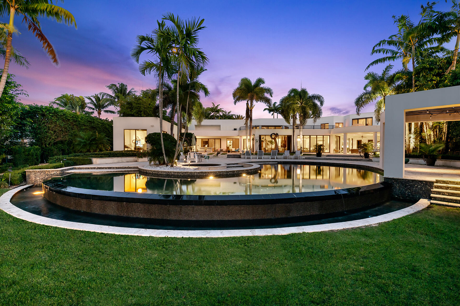 Set on a 1.36 acre lakefront lot, this beautiful contemporary estate was tastefully reconstructed in 2007. Facing west down a peaceful serene lake, this estate offers extreme privacy surrounded by lush tropical palm trees. Features of this residence include 5 bedrooms plus a theater room, office and massage room, infinity edge Pebble Tec Pool, Full house generator, impact windows, and high end summer kitchen. First floor includes the master bedroom, theater, office, massage room and guest bedroom. Second floor includes three guest bedrooms with ensuite bathrooms and a loft.