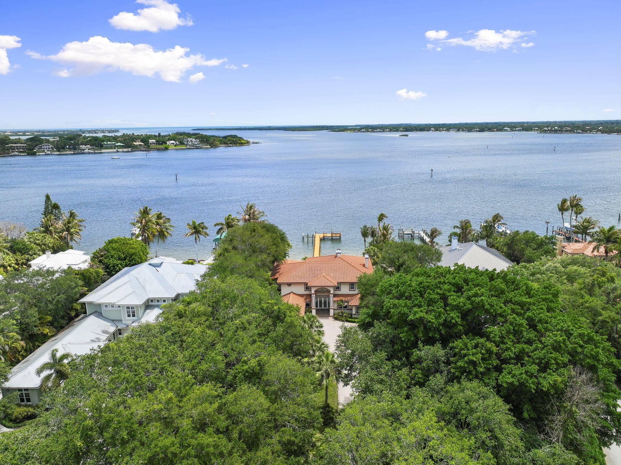 Set on one of the area's most desirable shaded streets, surrounded by estate lots, mature trees, private gated entrances, and a level of privacy that is increasingly hard to find, this Intracoastal estate delivers the kind of waterfront setting buyers wait years for.  Positioned on HIGH elevation with breathtaking water views, the property offers direct Intracoastal frontage, a deep water private dock, gated entry, and exceptional outdoor living with a pool and hot tub designed for relaxing, entertaining, and taking in the view.  Inside, the home features 4 bedrooms plus a versatile office or den, 4.5 bathrooms, elegant wood and marble flooring, and impact rated windows and doors throughout. Brand NEW SEAWALL, newer roof, windows, doors, and generator.