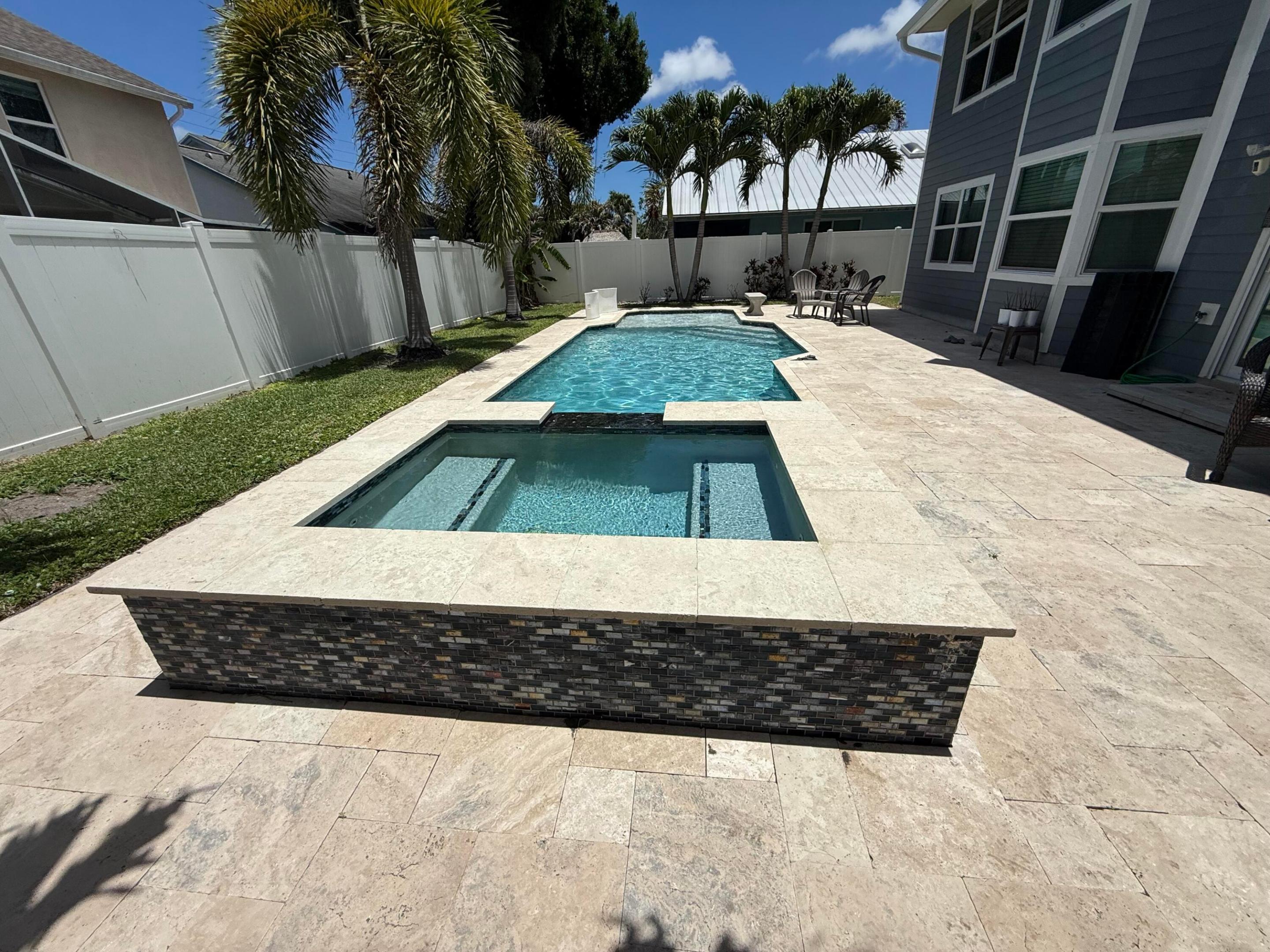 Rare opportunity in the highly sought-after community of North Palm Beach Heights! This stunning 4-bedroom, 2.5-bath pool home offers the perfect blend of elegance and functionality. The open-concept kitchen flows seamlessly into the family room and out to a spectacular custom saltwater pool and spa — ideal for entertaining. A spacious living room and formal dining room provide additional space to gather, while four generously sized bedrooms offer comfort .  Built to endure Florida's elements, the home features durable Hardie Plank siding, impact windows, and impact doors for year-round peace of mind. The oversized 50x25 stone paver patio and saltwater pool and spa with waterfall (updated 2019/2020) all equipped with an AquaCal electric heater, Jandy pool equipment,   and a WYBOT pool vacuum — all included. A 2-car garage and 5-car brick paver driveway complete this exceptional offering.  Inside photos coming soon.   Interior photos coming soon — this one won't last!